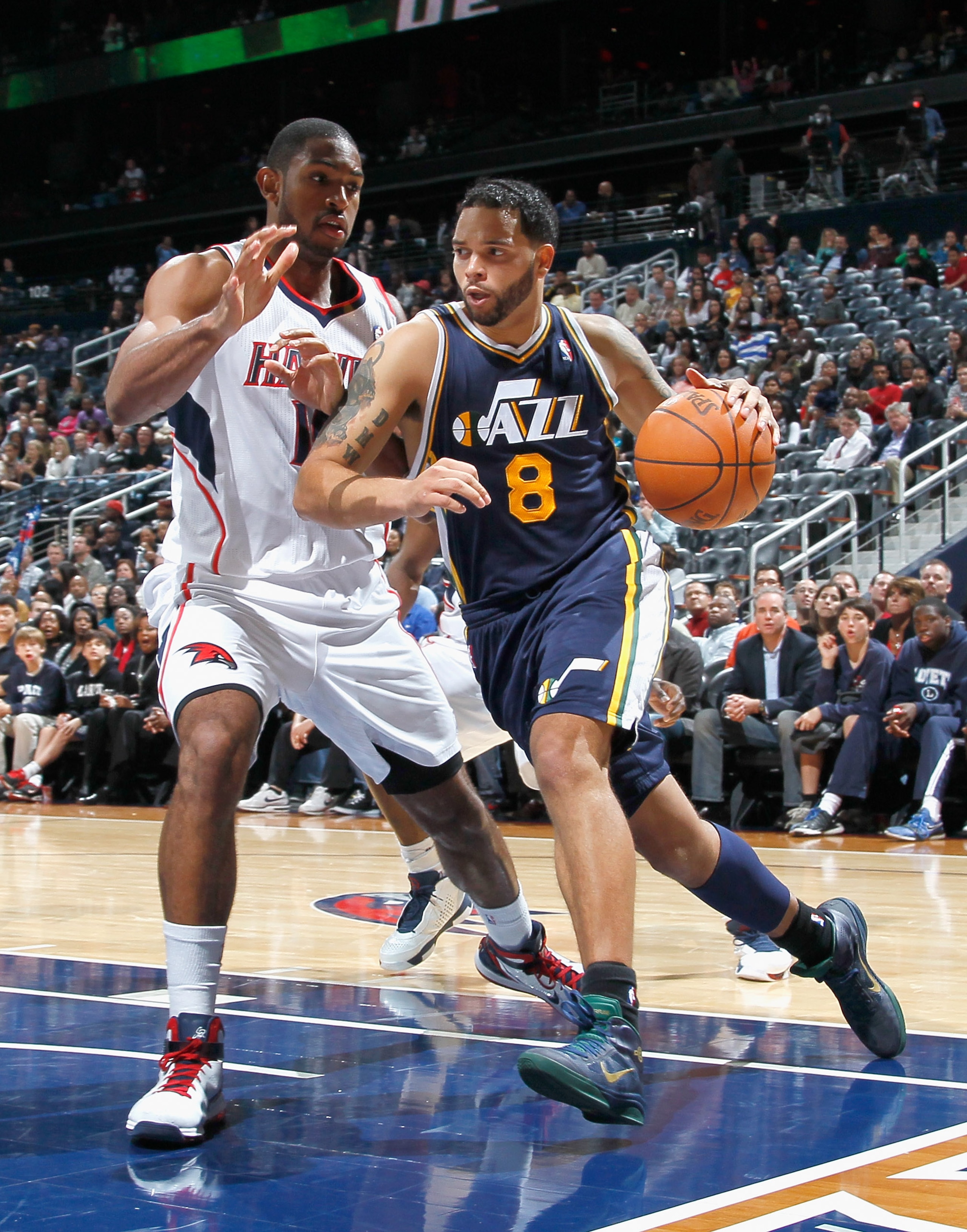 ATLANTA - NOVEMBER 12:  Deron Williams #8 of the Utah Jazz drives against Al Horford #15 of the Atlanta Hawks at Philips Arena on November 12, 2010 in Atlanta, Georgia.  NOTE TO USER: User expressly acknowledges and agrees that, by downloading and/or usin