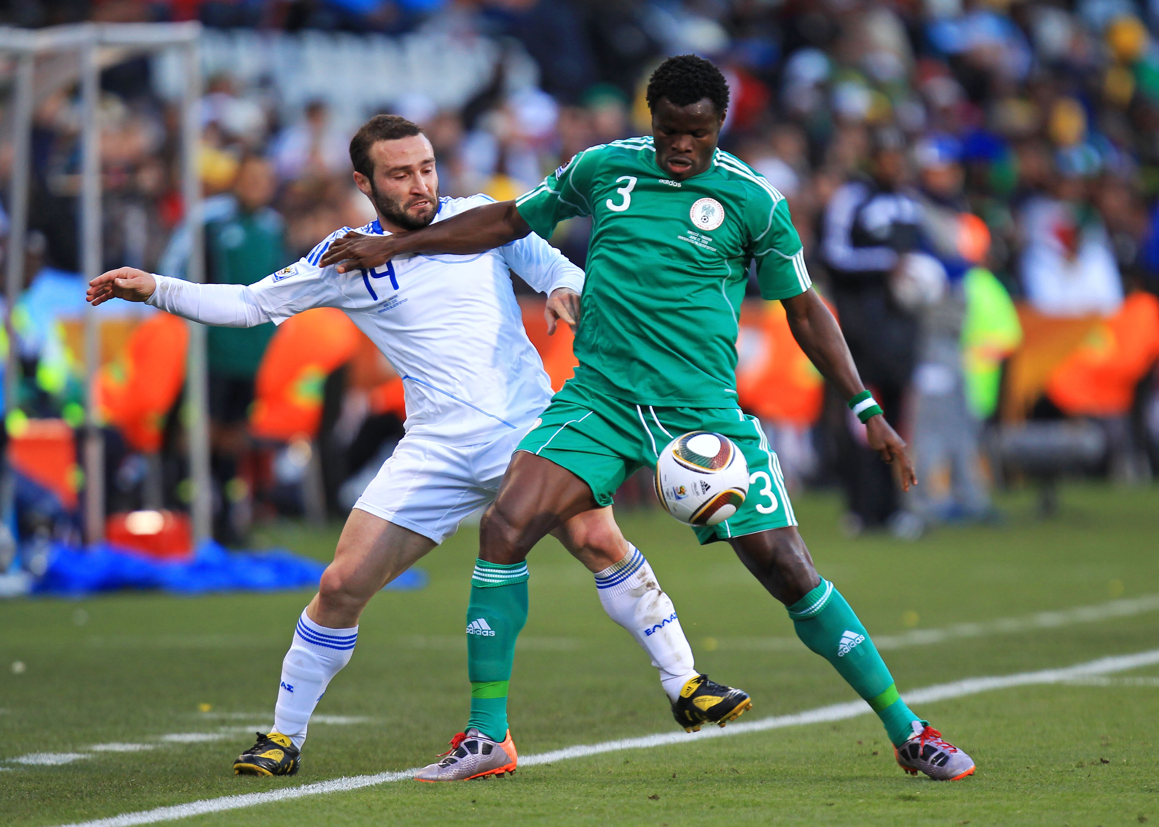 BLOEMFONTEIN, SOUTH AFRICA - JUNE 17: Taye Taiwo of Nigeria holds off Dimitrios Salpingidis of Greece during the 2010 FIFA World Cup South Africa Group B match between Greece and Nigeria at the Free State Stadium on June 17, 2010 in Mangaung/Bloemfontein,