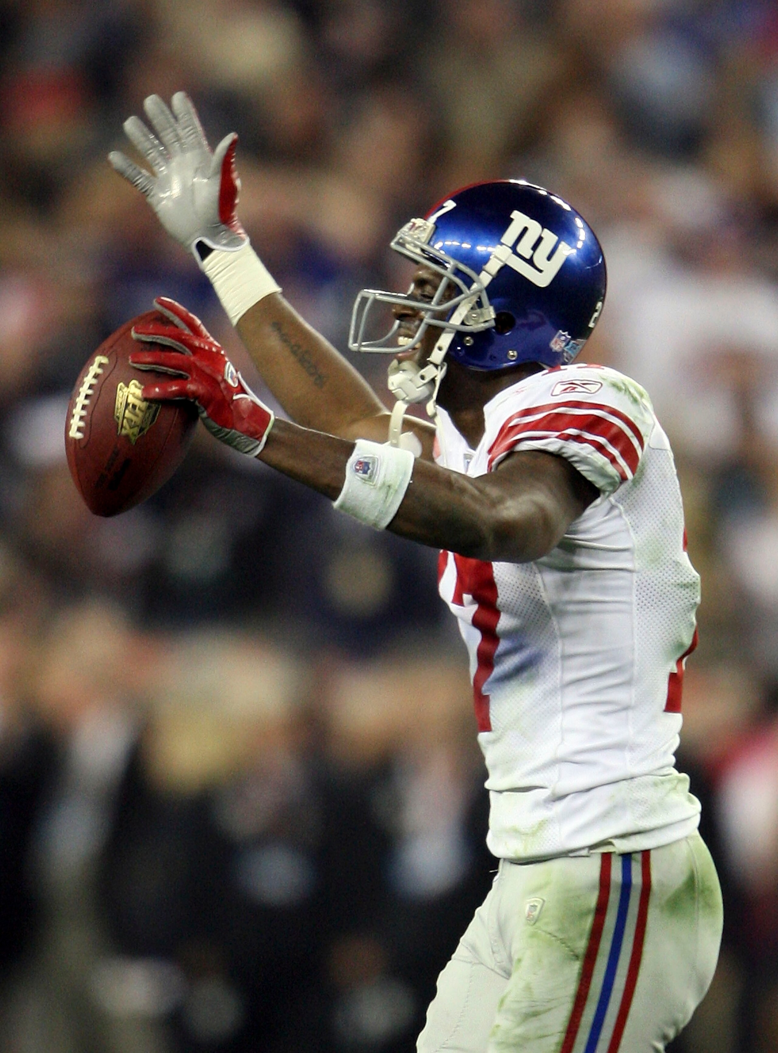 GLENDALE, AZ - FEBRUARY 03:  Wide receiver Plaxico Burress #17 of the New York Giants reacts after he catches a 13-yard touchdown pass in the fourth quarter over Ellis Hobbs #27 of the New England Patriots during Super Bowl XLII on February 3, 2008 at the