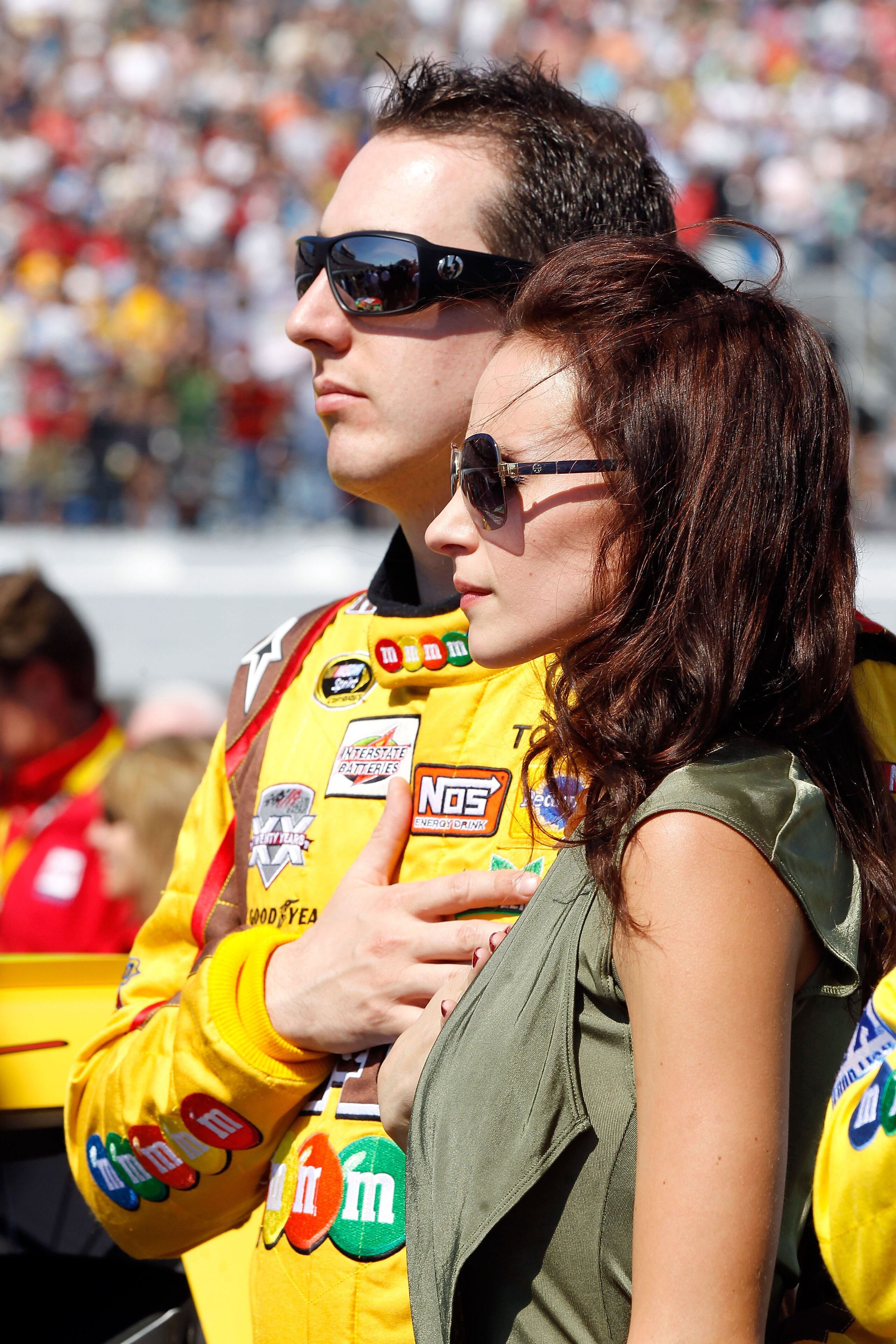 DAYTONA BEACH, FL - FEBRUARY 20:  Kyle Busch, driver of the #18 M&M'sToyota, and his wife Samantha Sarcinella take part in pre-race ceremonies during the NASCAR Sprint Cup Series Daytona 500 at Daytona International Speedway on February 20, 2011 in Dayton