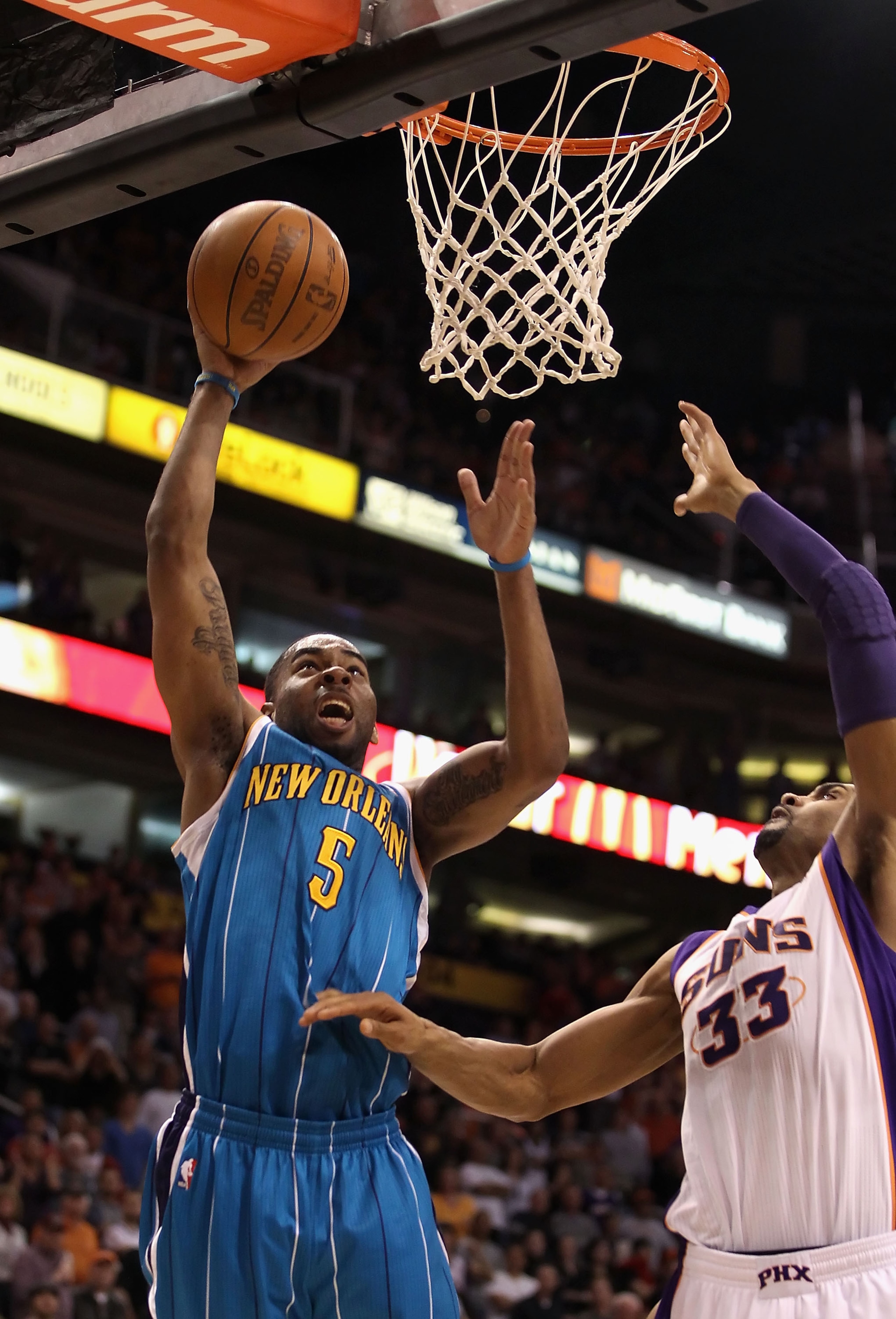 PHOENIX, AZ - JANUARY 30:  Marcus Thornton #5 of the New Orleans Hornets lays up a shot over Grant Hill #33 of the Phoenix Suns during the NBA game at US Airways Center on January 30, 2011 in Phoenix, Arizona. The Suns defeated the Hornets 104-102.  NOTE