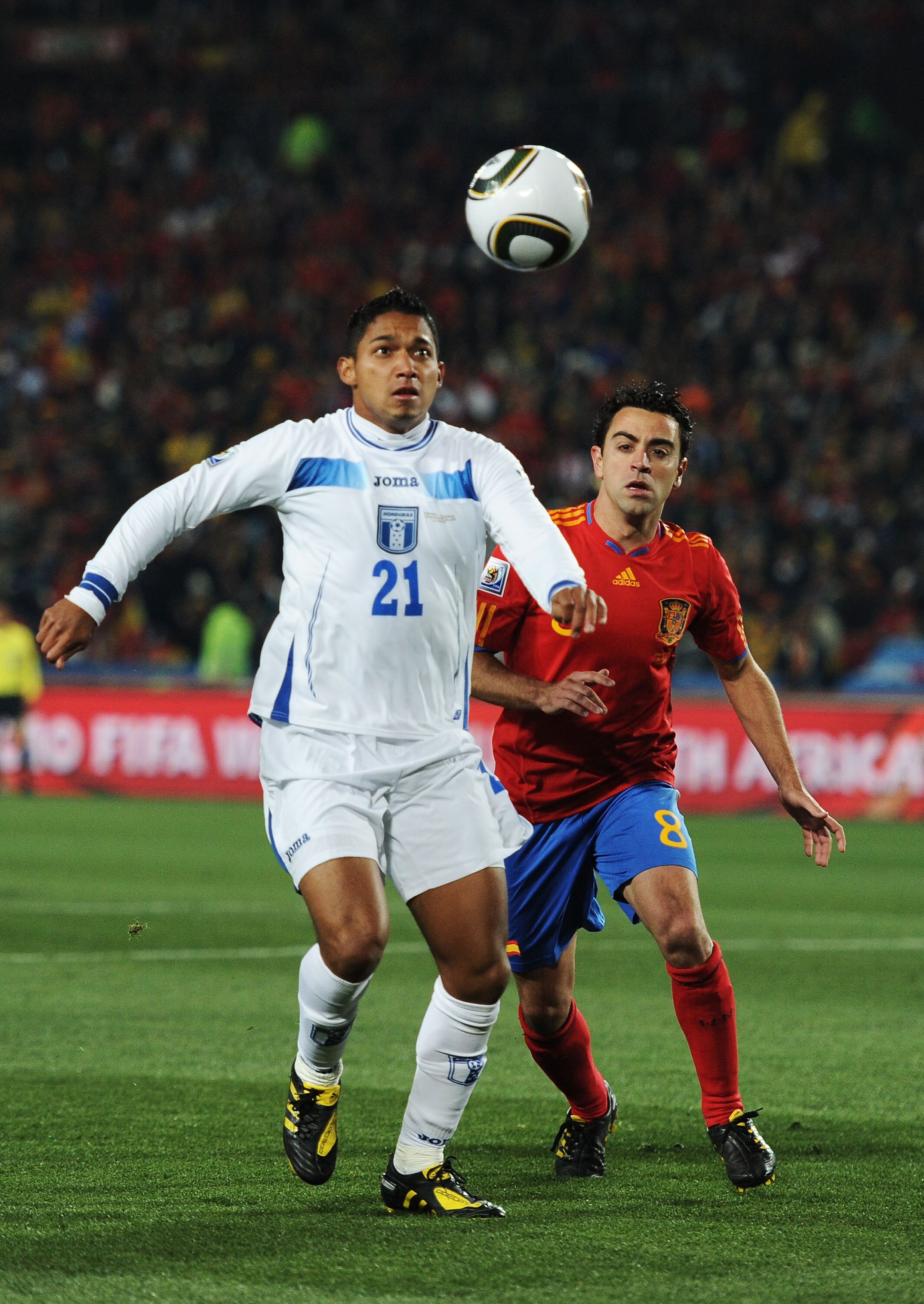 JOHANNESBURG, SOUTH AFRICA - JUNE 21: Xavi Hernandez of Spain challenges Emilio Izaguirre of Honduras during the 2010 FIFA World Cup South Africa Group H match between Spain and Honduras at Ellis Park Stadium on June 21, 2010 in Johannesburg, South Africa
