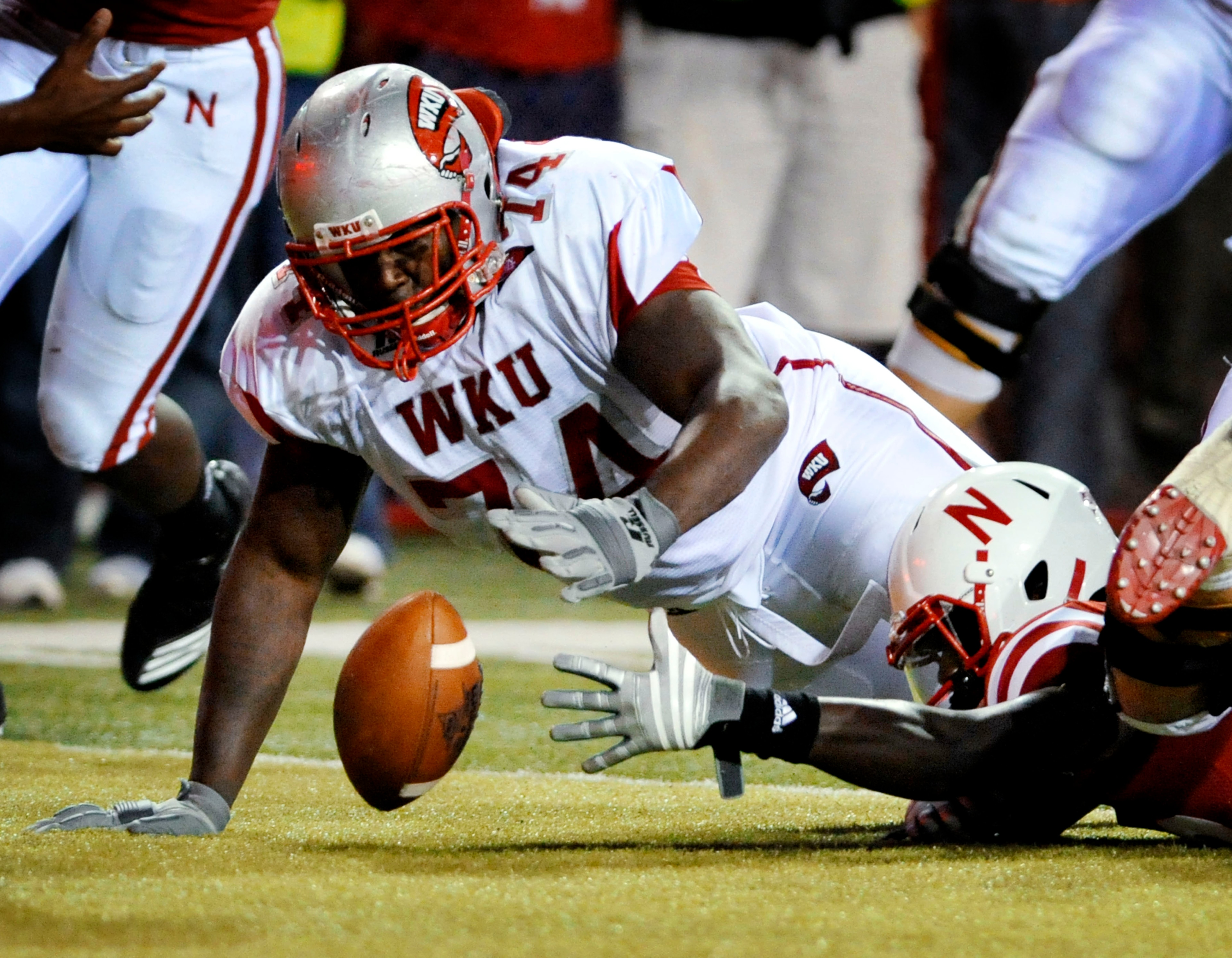 LINCOLN, NE - SEPTEMBER 04: P.J. Smith of the Nebraska Cornhuskers fights for a fumble with Mychal Patterson of the Western Kentucky Hilltoppers during second half action at Memorial Stadium on September 4, 2010 in Lincoln, Nebraska.  (Photo by Eric Franc
