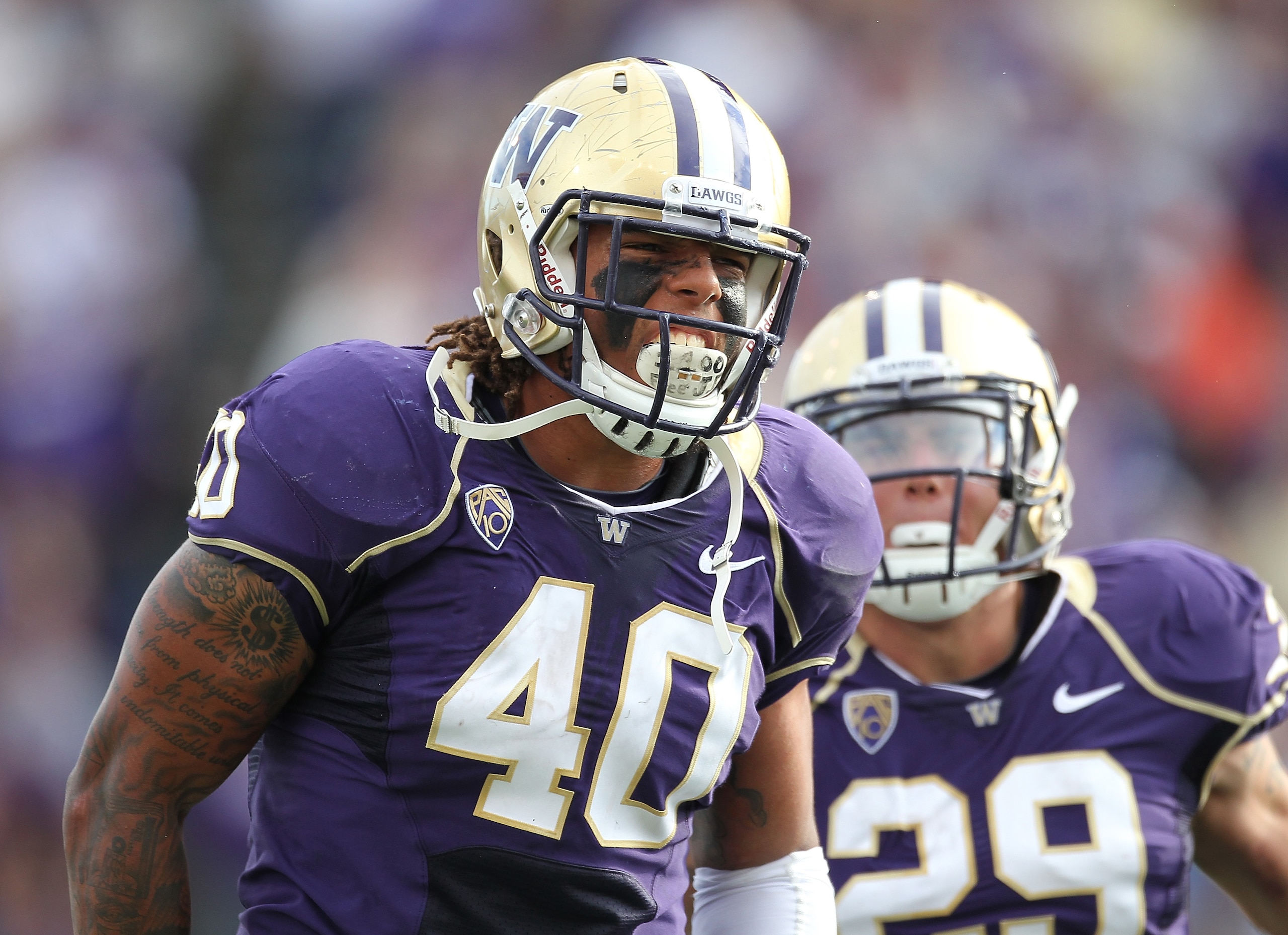 SEATTLE - SEPTEMBER 11:  Linebacker Mason Foster #40 of the Washington Huskies celebrates with Willis Wilson #29 after tackling quarterback Ryan Nassib #12 of the Syracuse Orange and causing a fumble on September 11, 2010 at Husky Stadium in Seattle, Wash