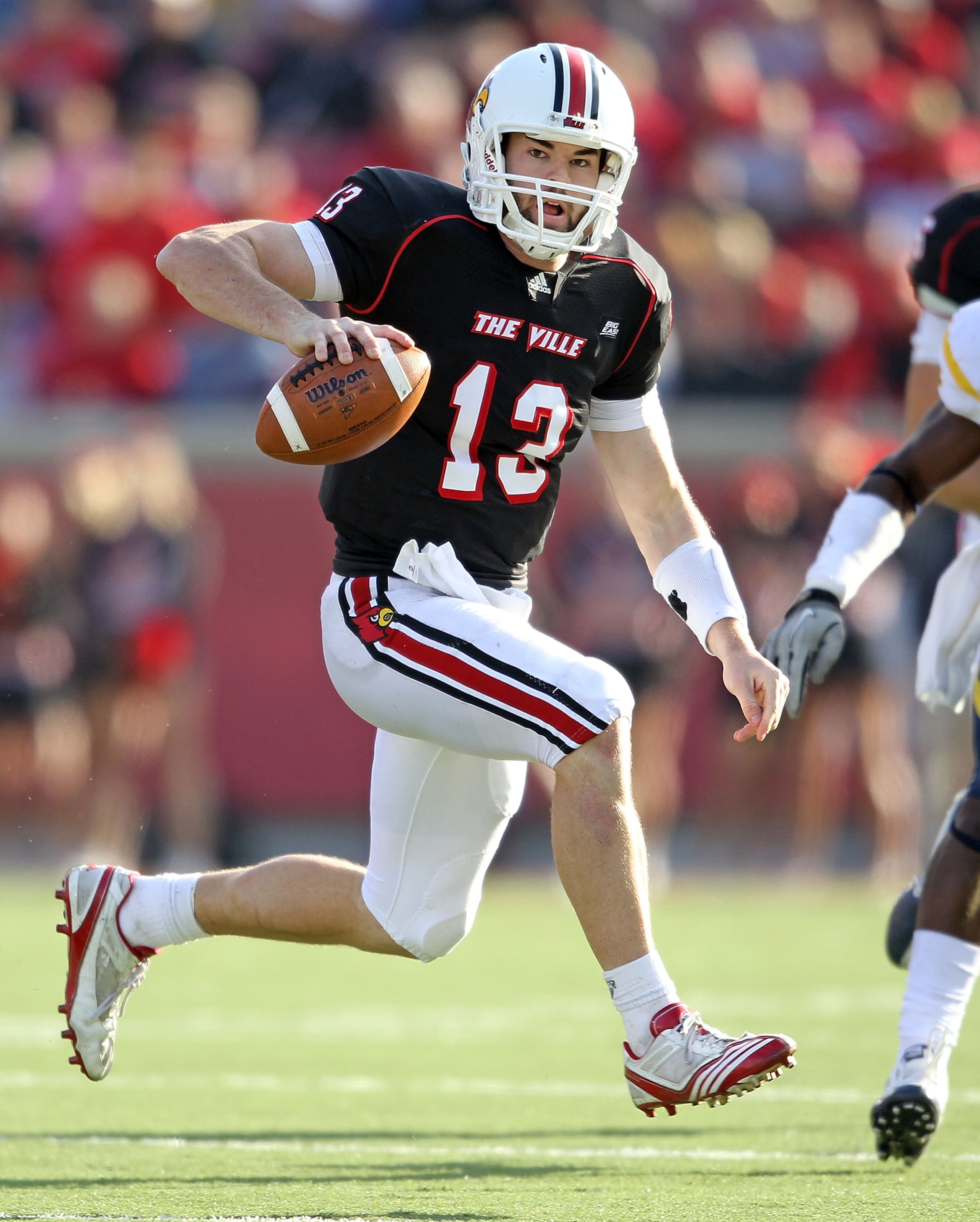 LOUISVILLE, KY - NOVEMBER 20: Justin Burke #13 of the Louisville Cardinals runs with the ball during the Big East Conference game against the West Virginia Mountaineers at Papa John's Cardinal Stadium on November 20, 2010 in Louisville, Kentucky. (Photo LOUISVILLE, KY - NOVEMBER 20: Justin Burke #13 of the Louisville Cardinals runs with the ball during the Big East Conference game against the West Virginia Mountaineers at Papa John's Cardinal Stadium on November 20, 2010 in Louisville, Kentucky. (Photo