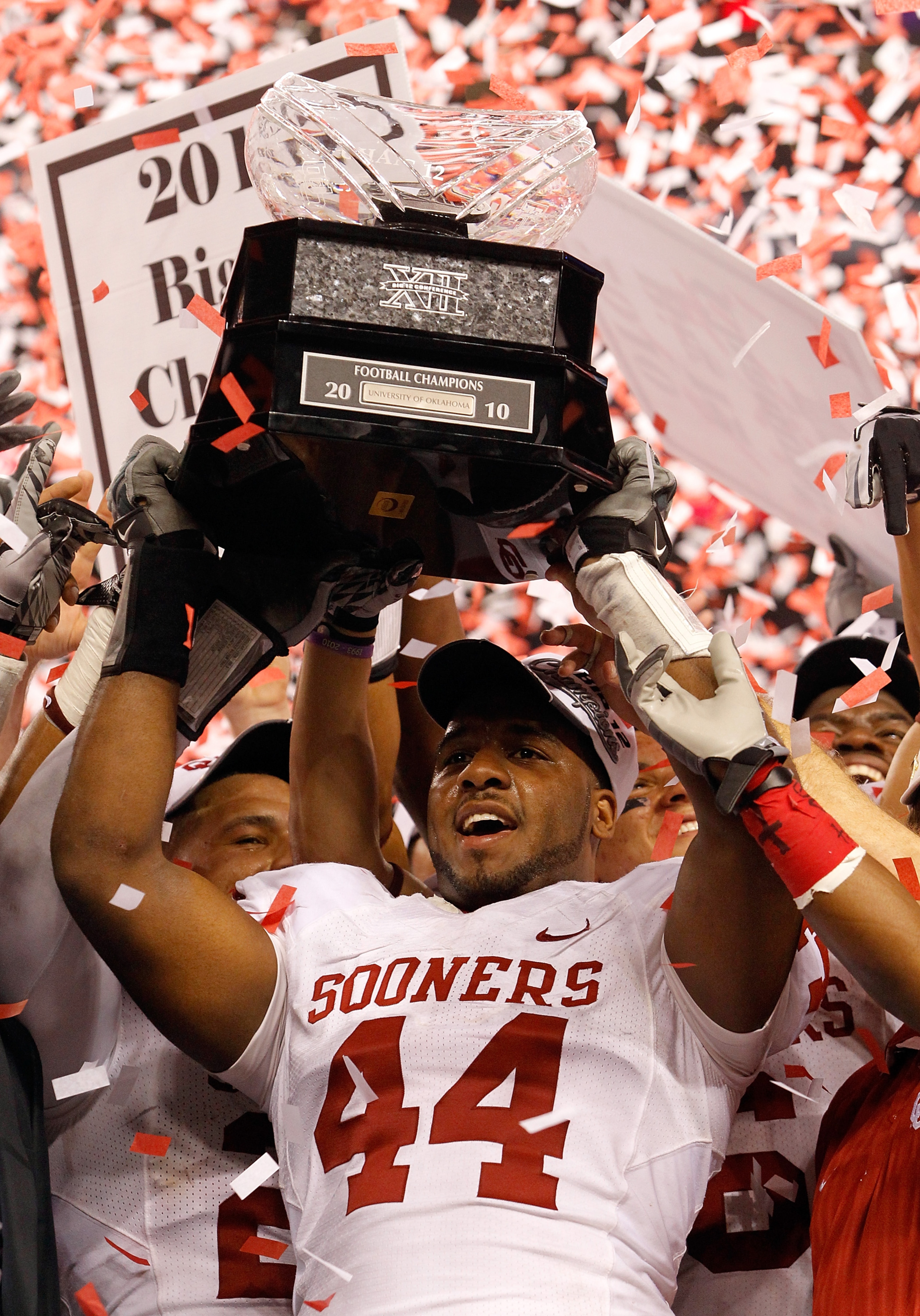 ARLINGTON, TX - DECEMBER 04:  Defensive end Jeremy Beal #44 of the Oklahoma Sooners celebrates with the Big 12 Championship Trophy after the Sooners beat the Nebraska Cornhuskers 23-20 at Cowboys Stadium on December 4, 2010 in Arlington, Texas.  (Photo by