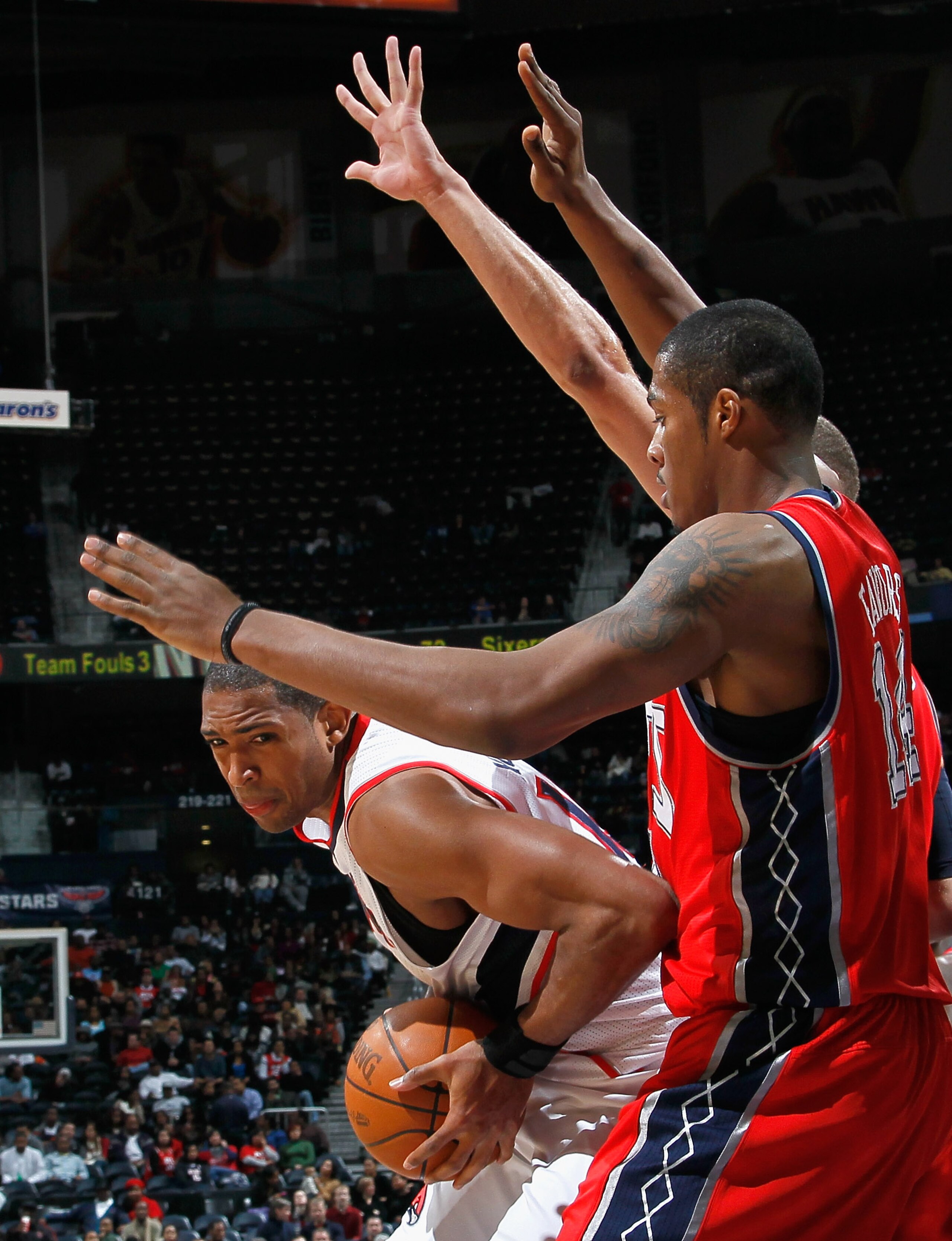 ATLANTA, GA - DECEMBER 07:  Al Horford #15 of the Atlanta Hawks drives against Derrick Favors #14 of the New Jersey Nets at Philips Arena on December 7, 2010 in Atlanta, Georgia.  NOTE TO USER: User expressly acknowledges and agrees that, by downloading a