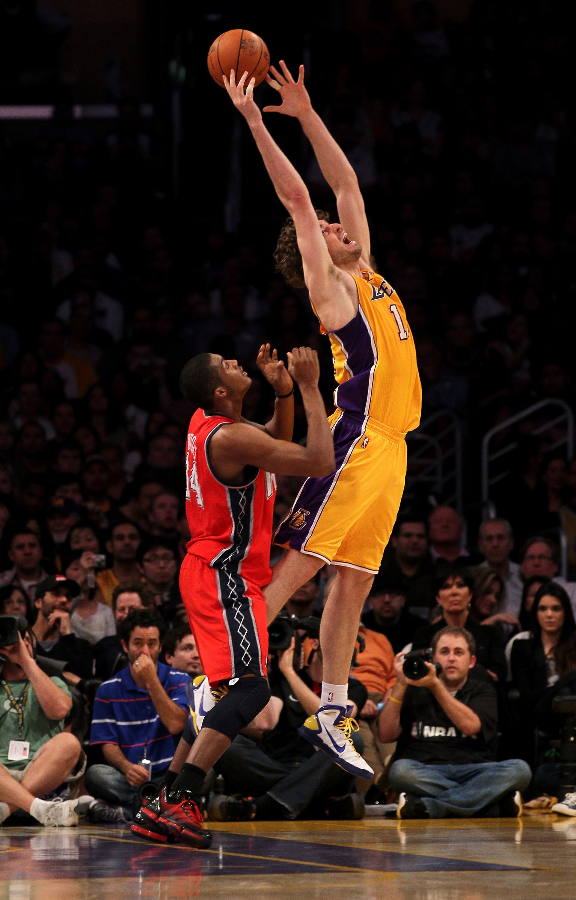 LOS ANGELES, CA - JANUARY 14:  Pau Gasol #16 of the Los Angeles Lakers reaches for a pass as he picks up a foul from Derrick Favors #14 of the New Jersey Nets at Staples Center on January 14, 2011 in Los Angeles, California.  NOTE TO USER: User expressly