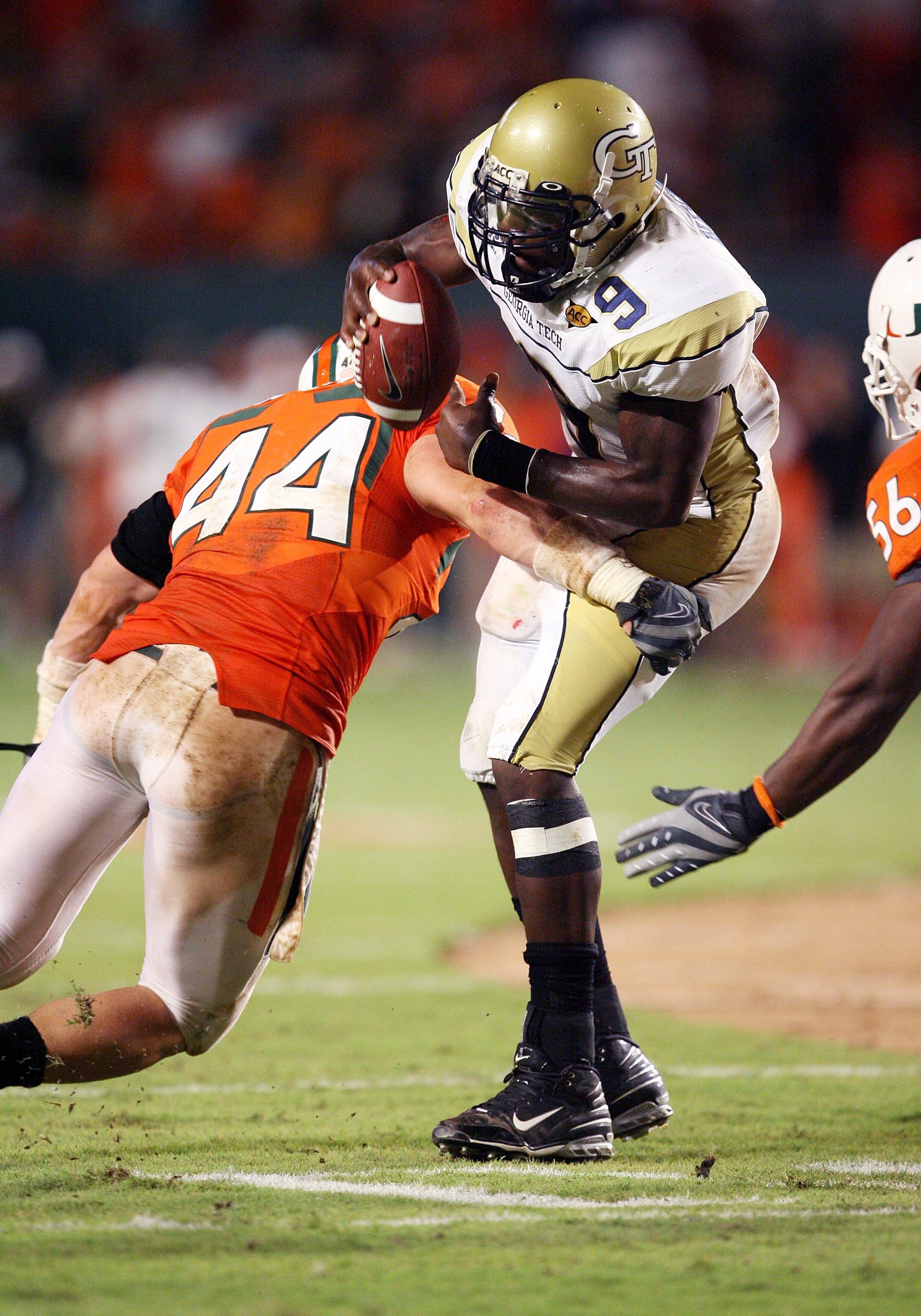 FORT LAUDERDALE, FL - SEPTEMBER 17:  Quarterback Josh Nesbitt #9 of the Georgia Tech Yellow Jackets is brought down by linebacker Colin McCarthy #44 of the Miami Hurricanes at Land Shark Stadium on September 17, 2009 in Fort Lauderdale, Florida. Miami def