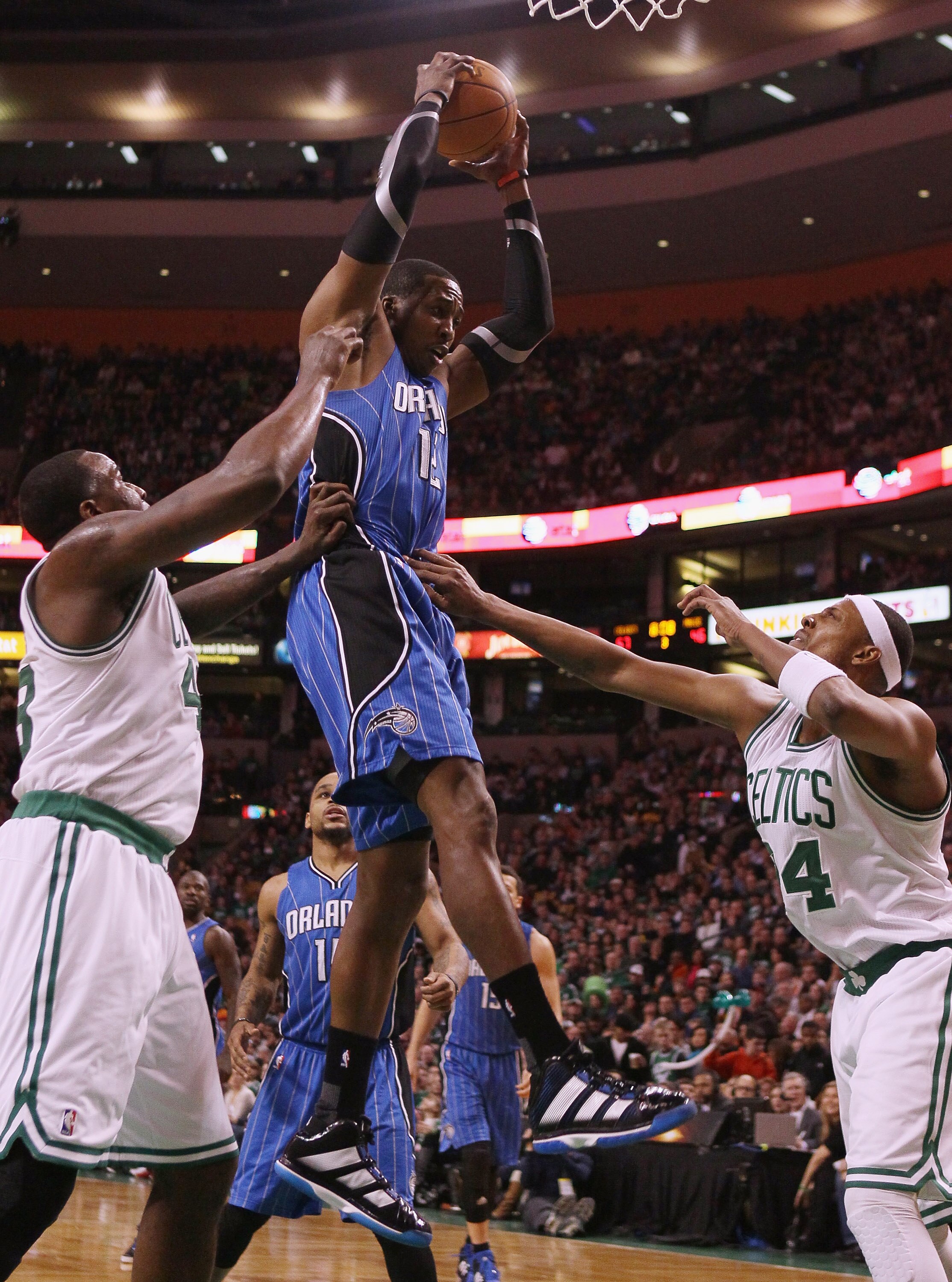 BOSTON, MA - FEBRUARY 06:  Dwight Howard #12 of the Orlando Magic grabs the rebound before Kendrick Perkins #43 and Paul Pierce #34 of the Boston Celtics on February 6, 2011 at the TD Garden in Boston, Massachusetts. The Celtics defeated the Magic 91-80.