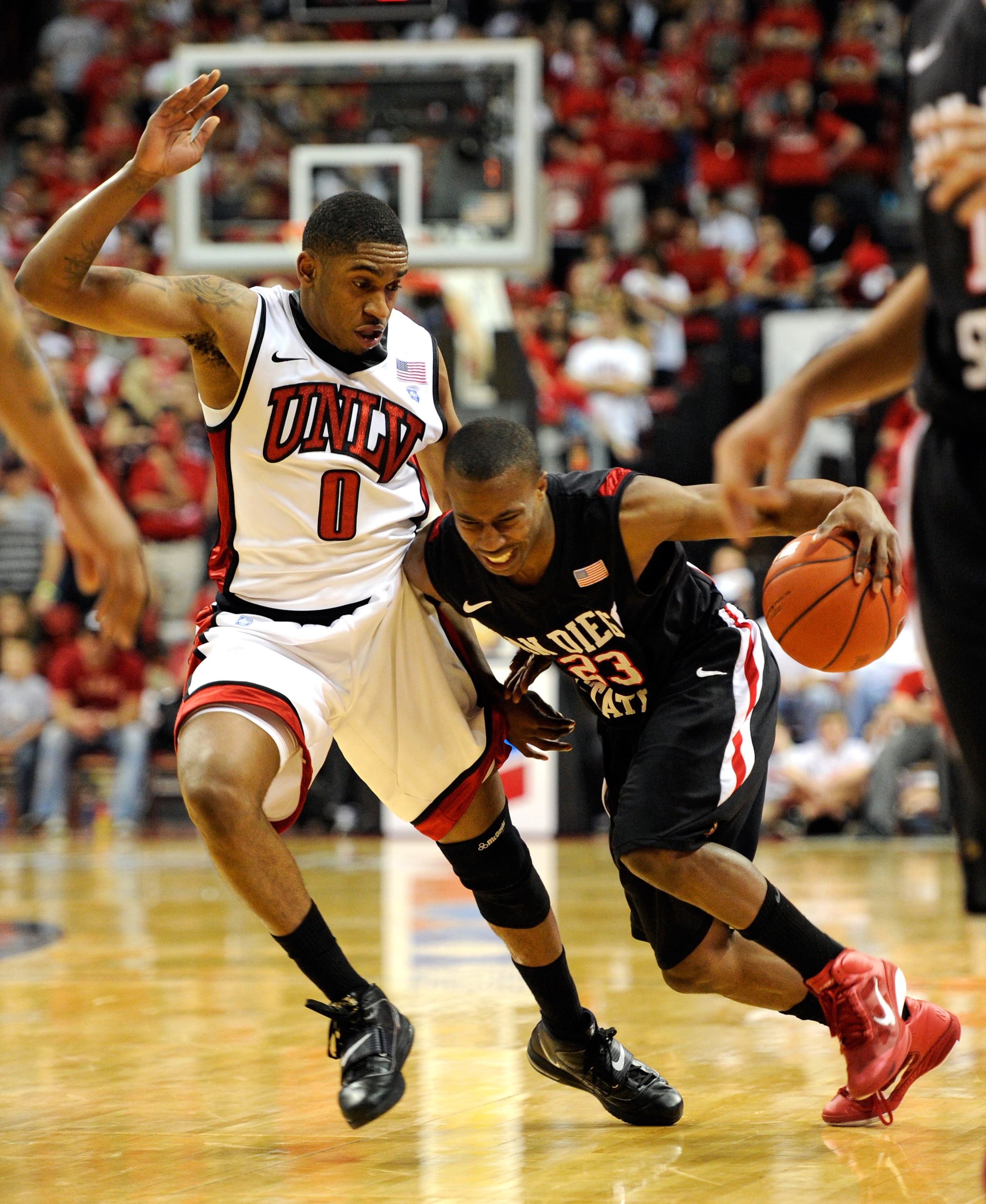 LAS VEGAS, NV - FEBRUARY 12:  D.J. Gay #23 of the San Diego State Aztecs drives against Oscar Bellfield #0 of the UNLV Rebels during their game at the Thomas & Mack Center February 12, 2011 in Las Vegas, Nevada. San Diego State won 63-57.  (Photo by Ethan