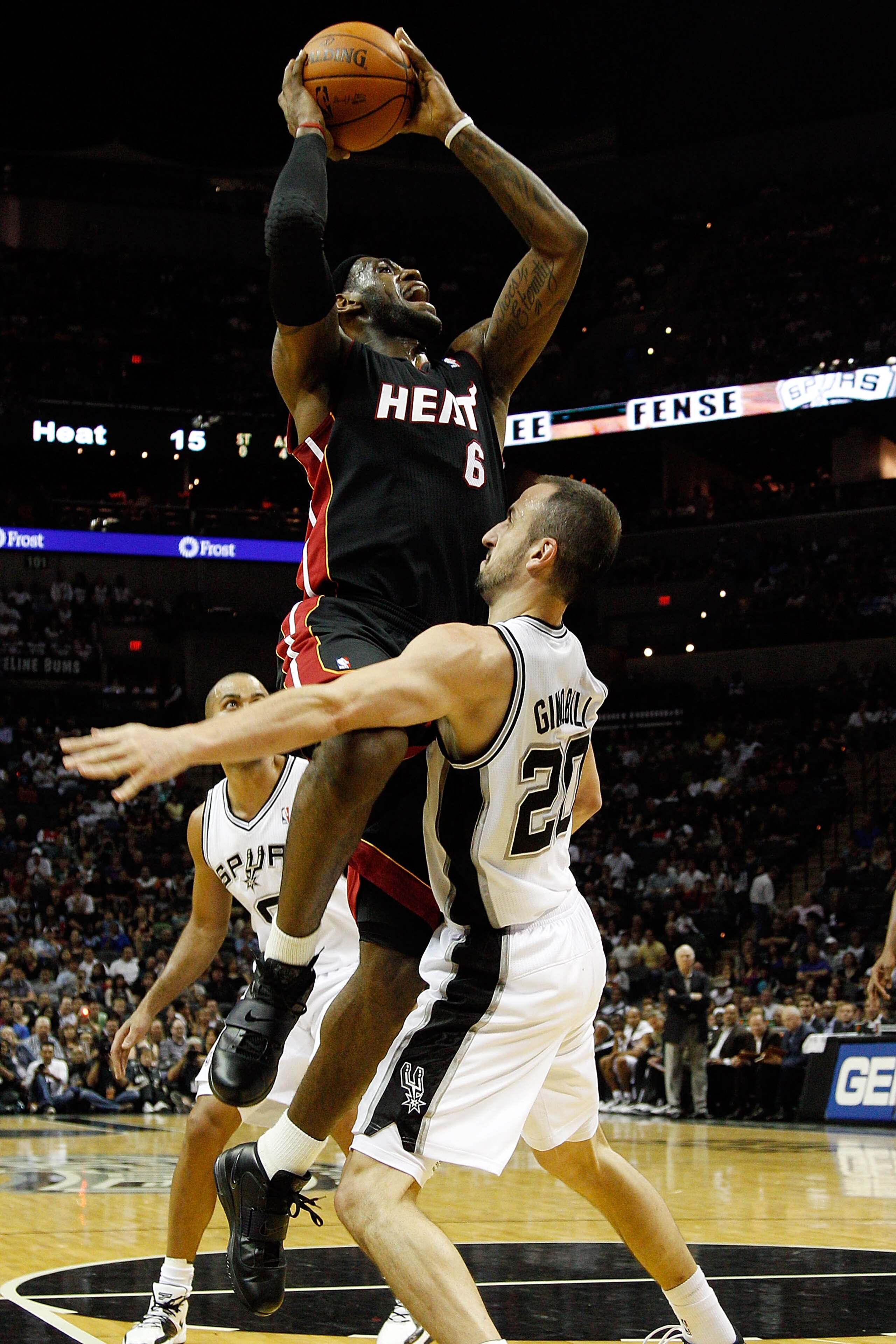 SAN ANTONIO - OCTOBER 09:  LeBron James #6 of the Miami Heat makes a shot over Manu Ginobili #20 of the San Antonio Spurs at the AT&T Center on October 9, 2010 in San Antonio, Texas.  NOTE TO USER: User expressly acknowledges and agrees that, by downloadi