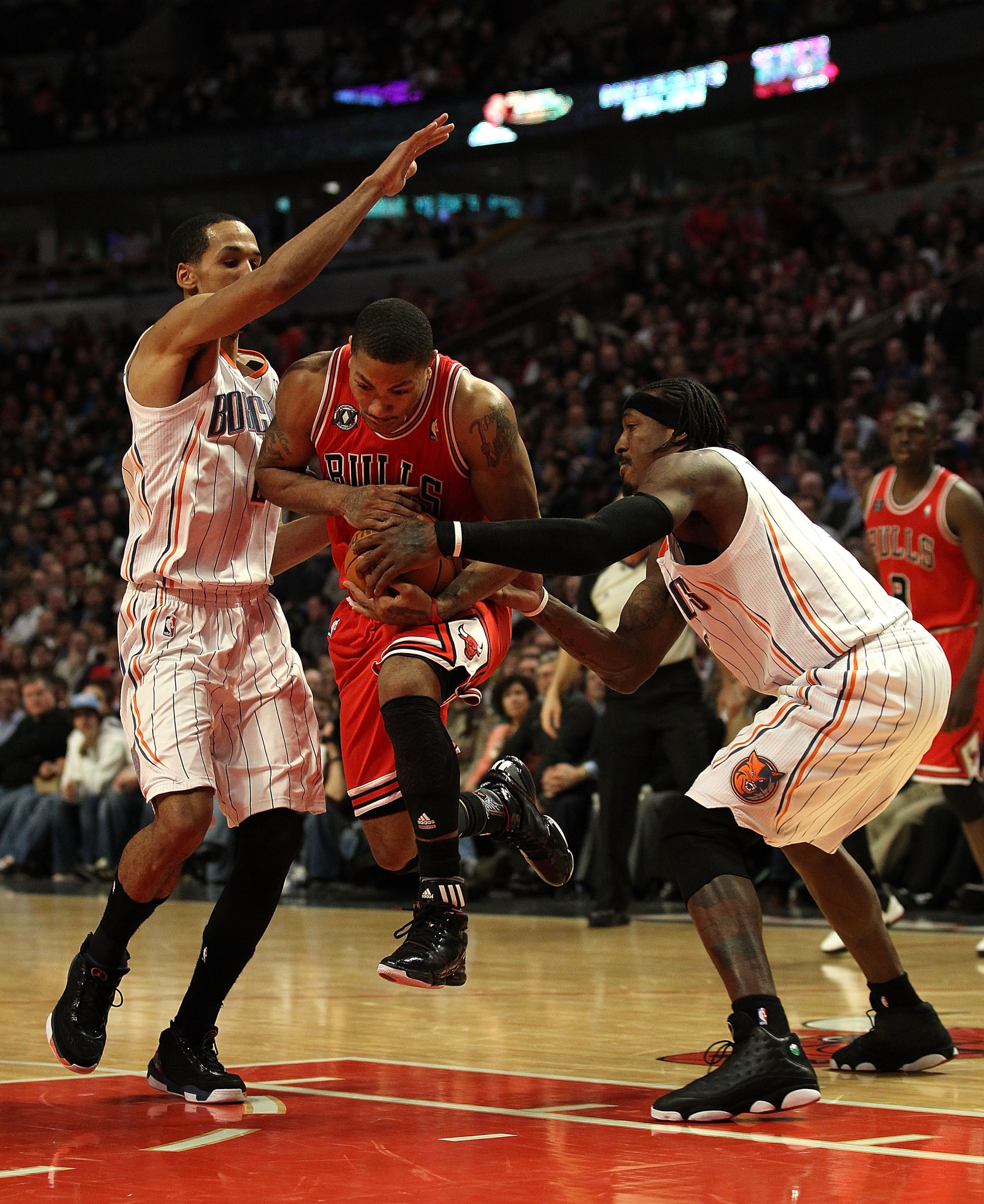 CHICAGO, IL - FEBRUARY 15: Derrick Rose #1 of the Chicago Bulls moves between Shaun Livingston #2 and Gerald Wallace #3 of the Charlotte Bobcats at the United Center on February 15, 2011 in Chicago, Illinois. The Bulls defeated the Bobcats 106-94. NOTE TO