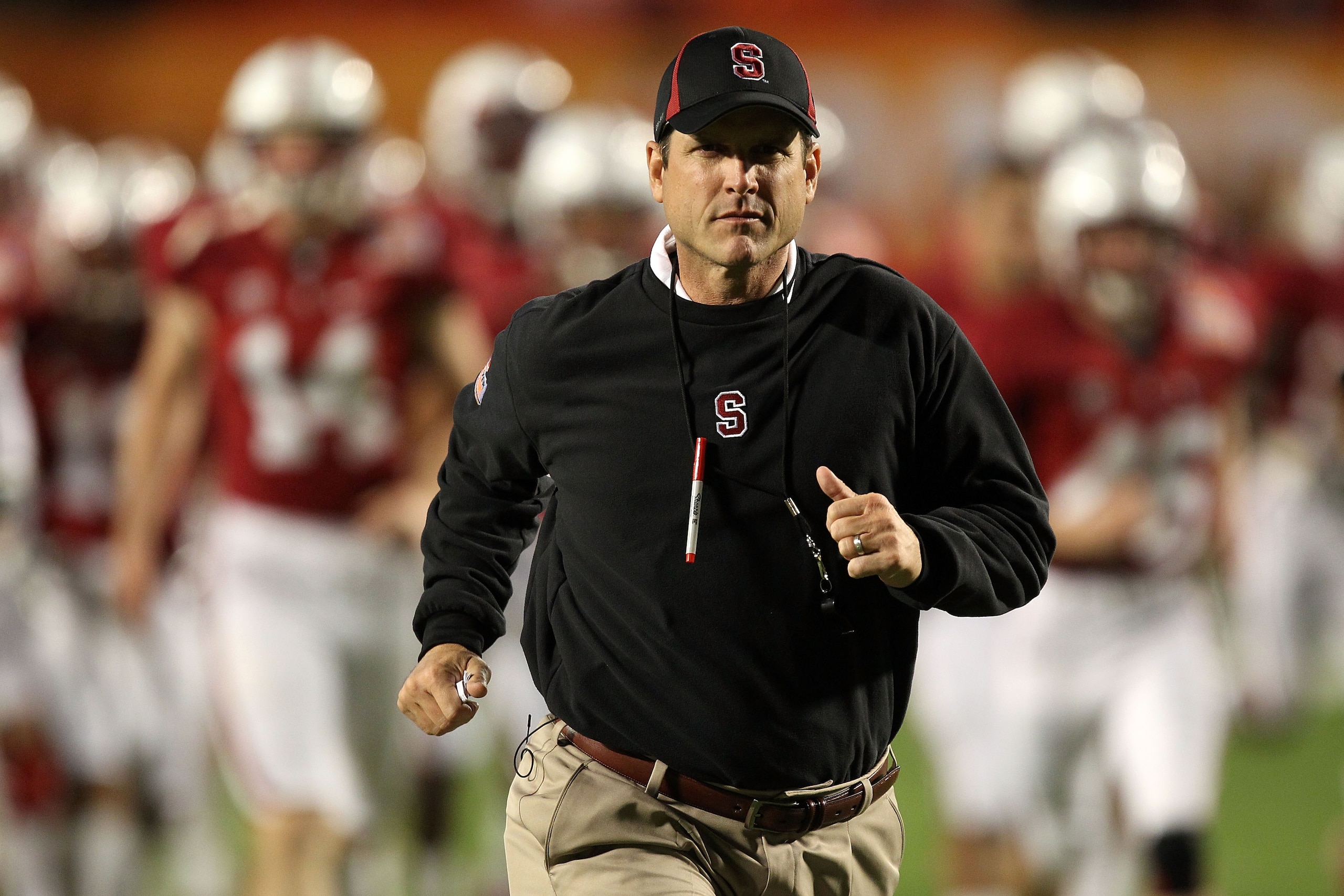 MIAMI, FL - JANUARY 03:  Head coach Jim Harbaugh of the Stanford Cardinal runs on the field during warm ups against the Virginai Tech Hokies during the 2011 Discover Orange Bowl at Sun Life Stadium on January 3, 2011 in Miami, Florida.  (Photo by Streeter