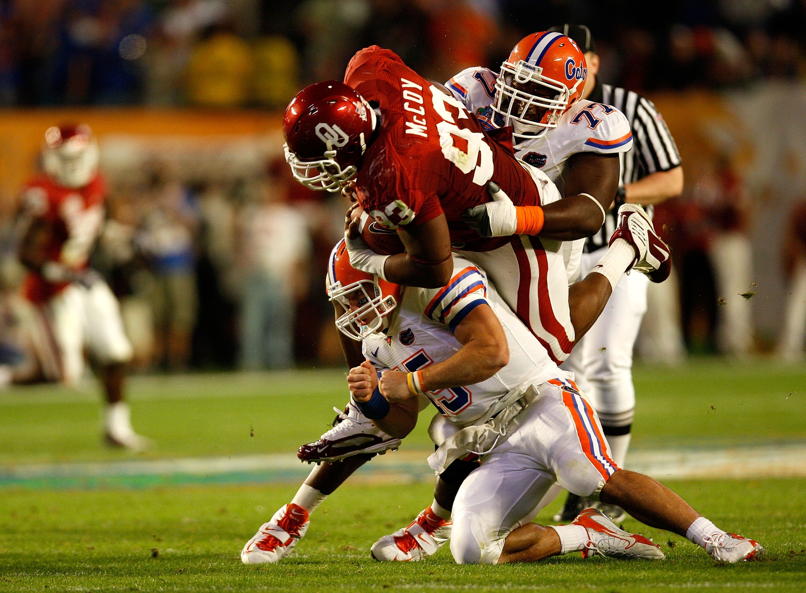 MIAMI - JANUARY 08:  Gerald McCoy #93 of the Oklahoma Sooners is tackled by Tim Tebow #15 and Jason Watkins #77 of the Florida Gators during the first half of the FedEx BCS National Championship game at Dolphin Stadium on January 8, 2009 in Miami, Florida