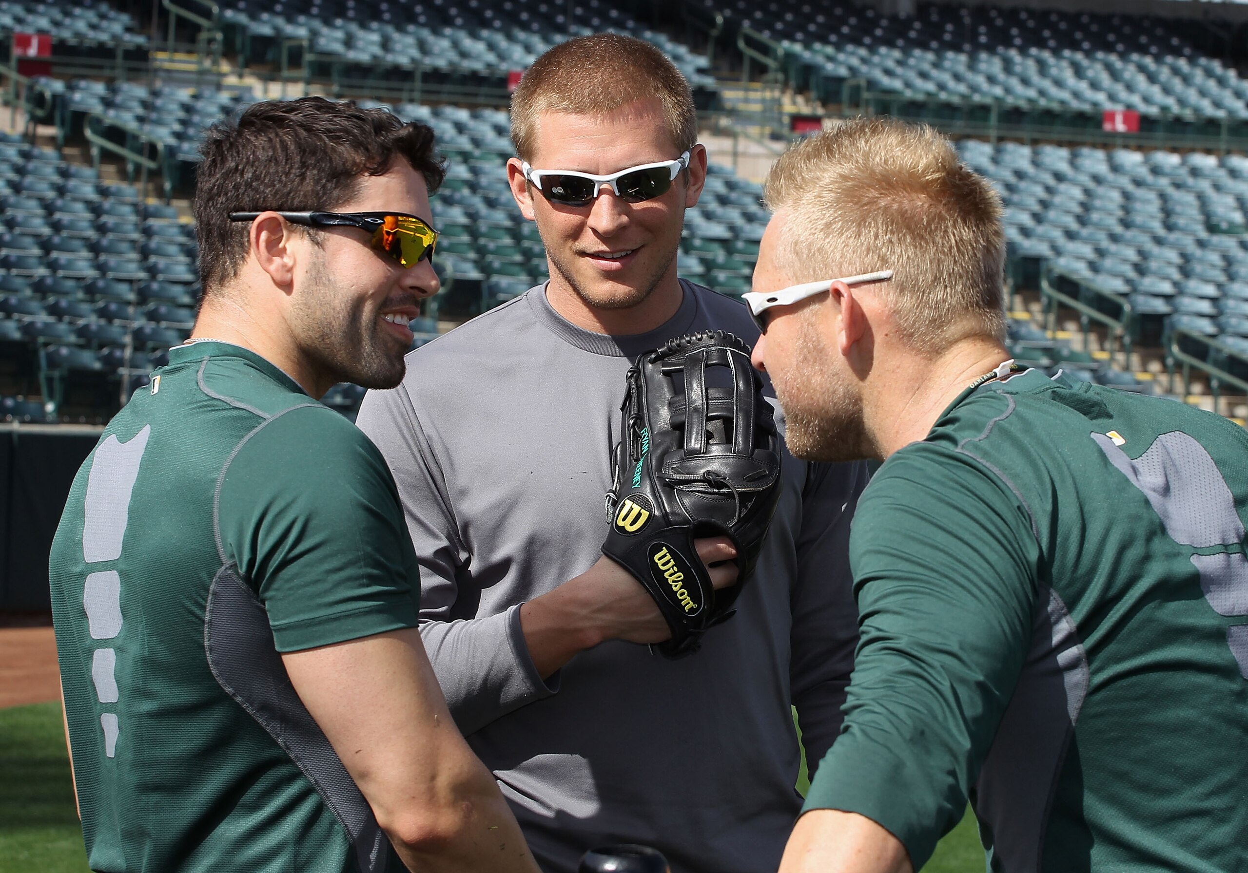 PHOENIX, AZ - FEBRUARY 16:  David DeJesus #12, Ryan Sweeney#15 and Daric Barton #10 of the Oakland Athletics talk during a MLB spring training practice at Phoenix Municipal Stadium on February 16, 2011 in Phoenix, Arizona.  (Photo by Christian Petersen/Ge