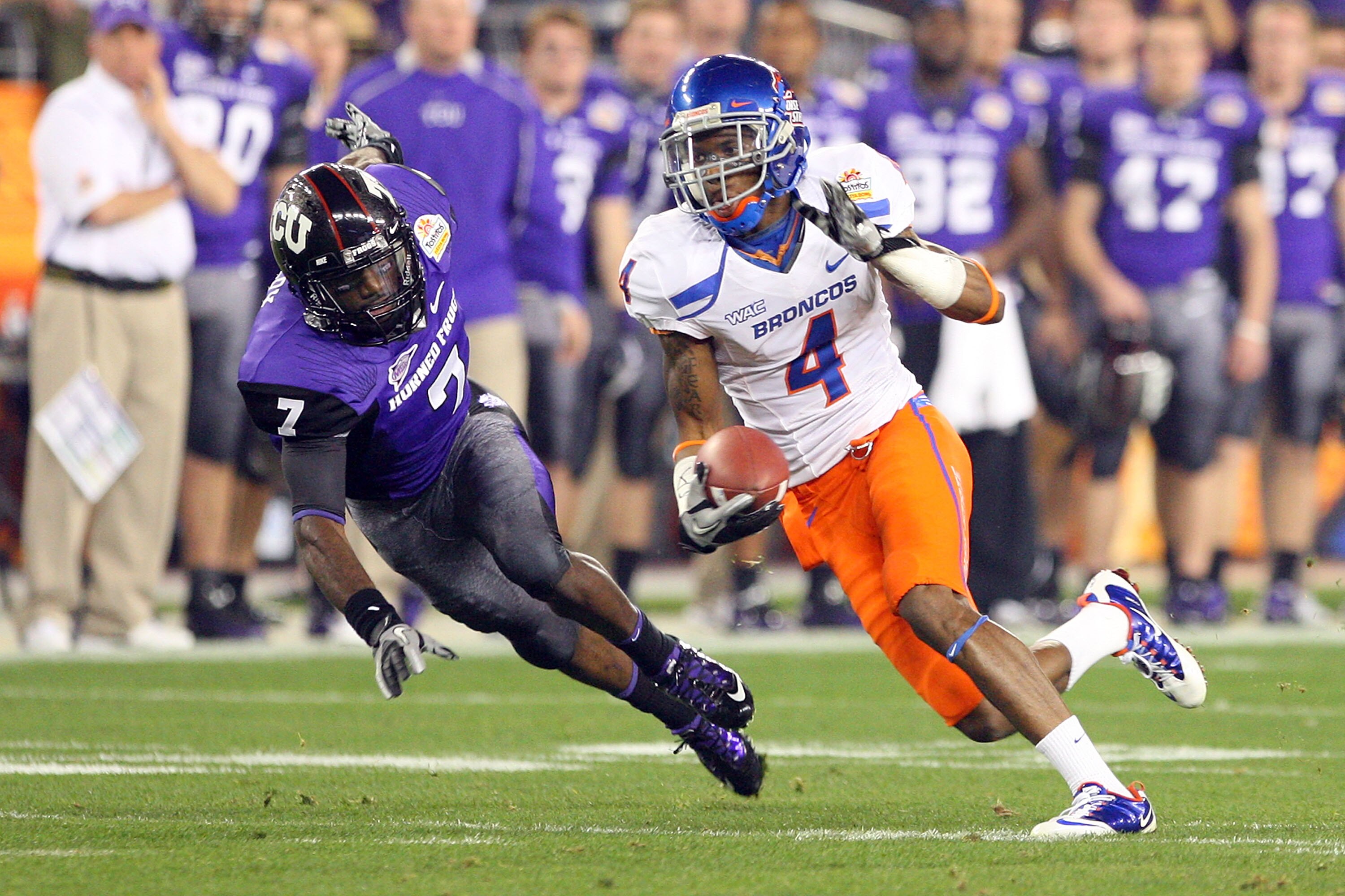 GLENDALE, AZ - JANUARY 04:  Titus Young #4 of the Boise State Broncos runs after a catch past Greg McCoy #7 of the TCU Horned Frogs in the first half during the Tostitos Fiesta Bowl at the Universtity of Phoenix Stadium on January 4, 2010 in Glendale, Ari