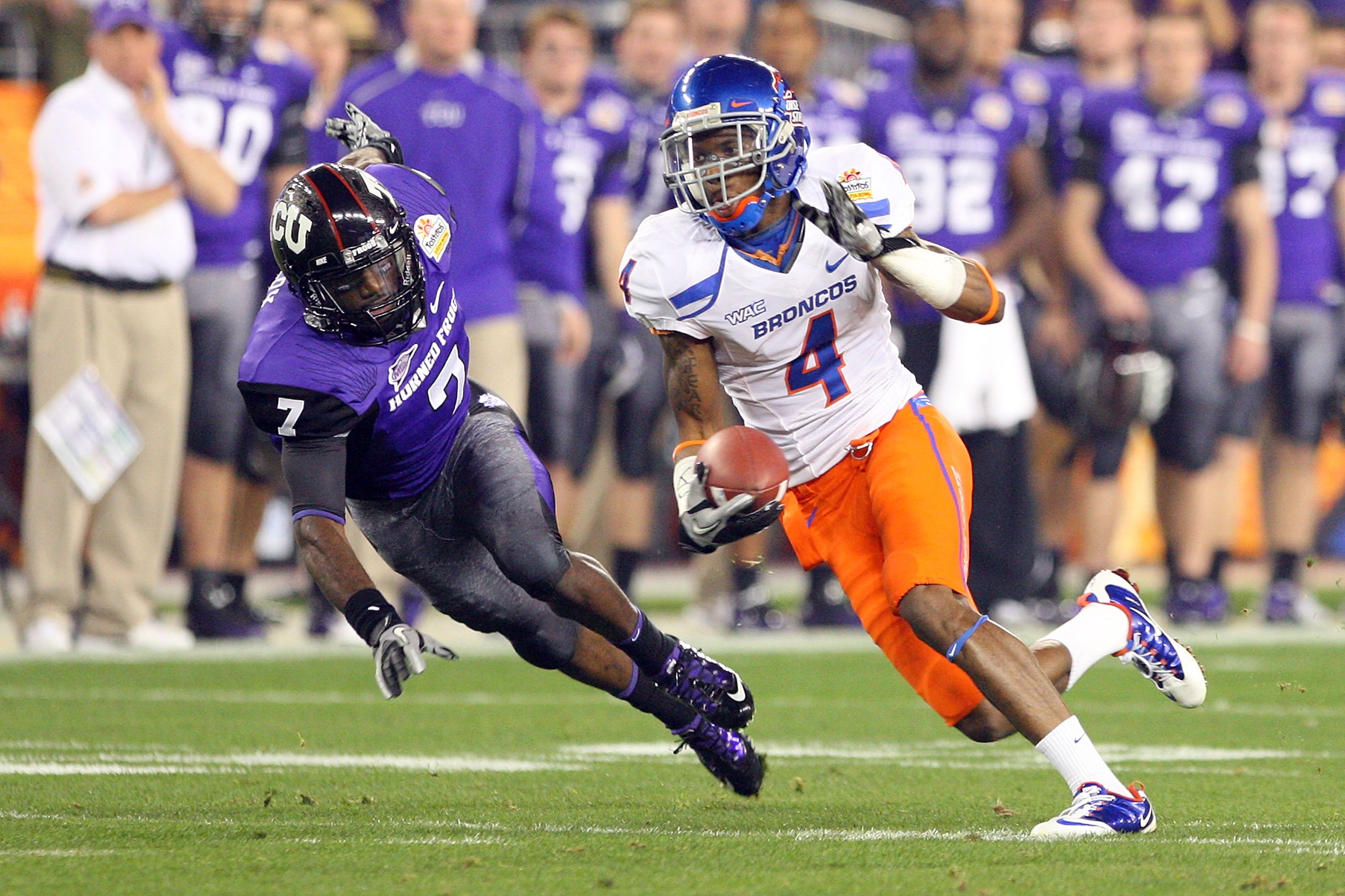 GLENDALE, AZ - JANUARY 04:  Titus Young #4 of the Boise State Broncos runs after a catch past Greg McCoy #7 of the TCU Horned Frogs in the first half during the Tostitos Fiesta Bowl at the Universtity of Phoenix Stadium on January 4, 2010 in Glendale, Ari