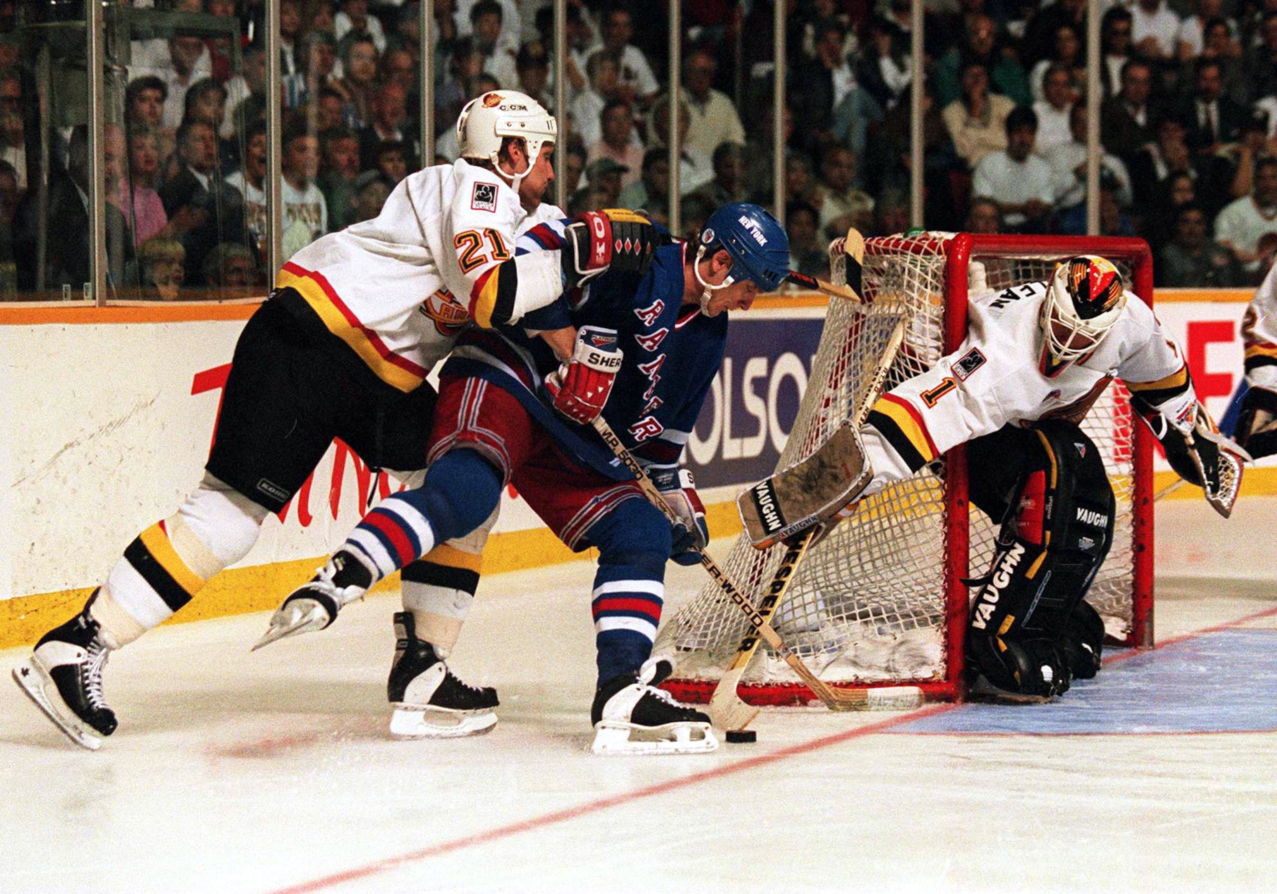 7 Jun 1994: RANGERS FORWARD STEVE LARMER IS MANHANDLED BY CANUCKS DEFENSEMAN JYRKI LUMME WHILE GOALTENDER KIRK MCLEAN POKE-CHECKS AWAY THE PUCK DURING THE THIRD OF GAME FOUR OF THE STANLEY CUP FINALS IN VANCOUVER, BRITISH COLUMBIA. LUMME WAS CALLED FOR A