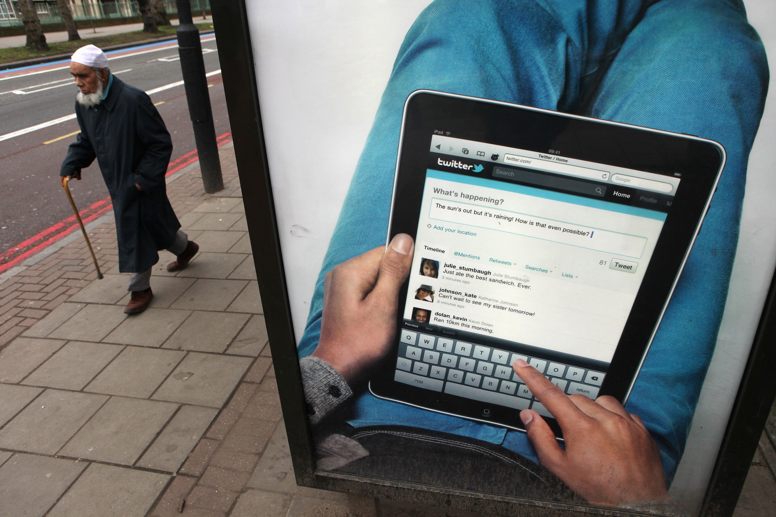 STRATFORD, ENGLAND - JANUARY 25: A man walks past an billboard on the A11 road in east London, which was due to form part of the Olympic marathon route in 2012, however the race will now be staged entirely in central London, on January 25, 2011 in London STRATFORD, ENGLAND - JANUARY 25: A man walks past an billboard on the A11 road in east London, which was due to form part of the Olympic marathon route in 2012, however the race will now be staged entirely in central London, on January 25, 2011 in London