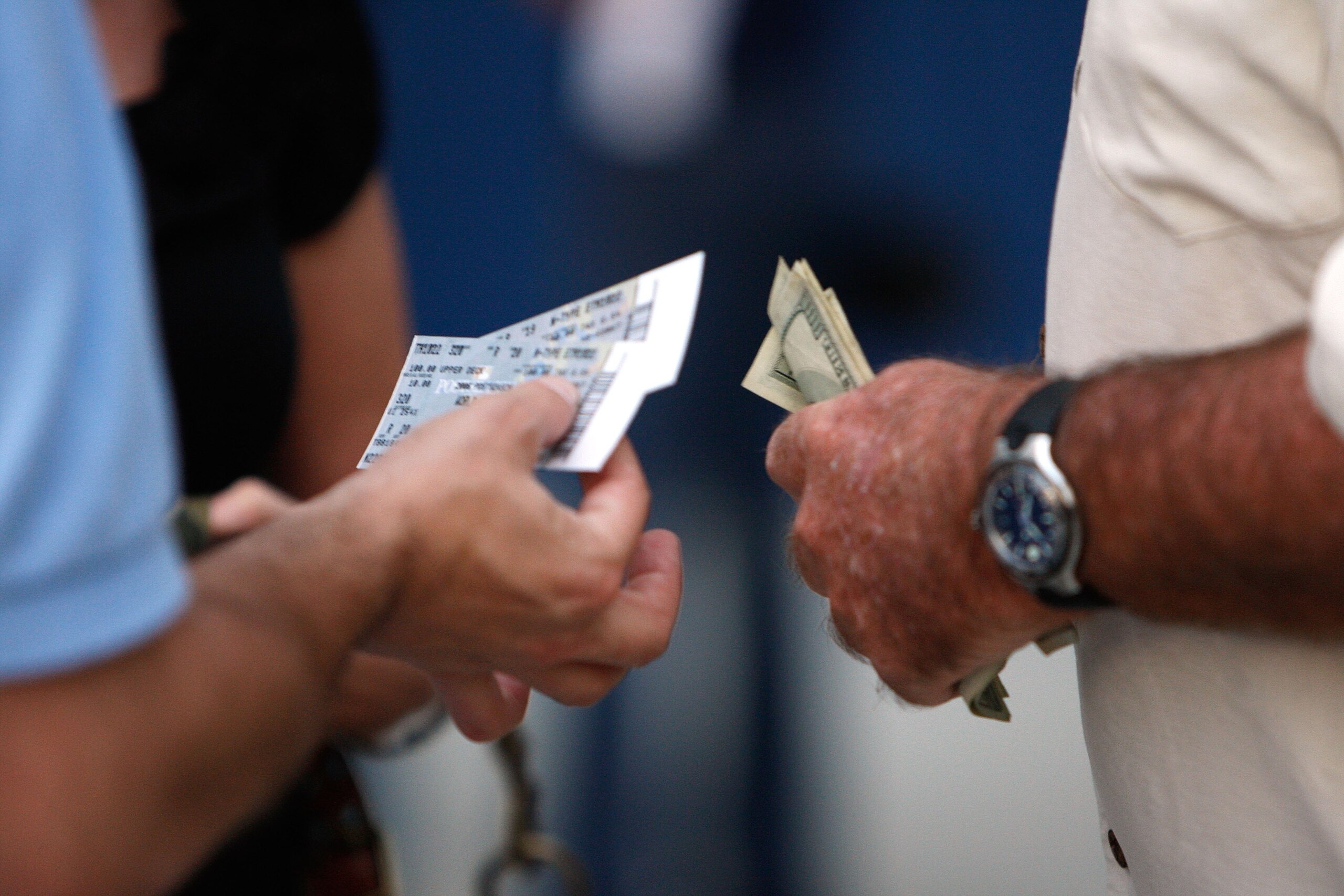 ST PETERSBURG, FL - OCTOBER 22:  A fan holds tickets and another holds money before the Philadelphia Phillies take on the Tampa Bay Rays during game one of the 2008 MLB World Series on October 22, 2008 at Tropicana Field in St. Petersburg, Florida.  (Phot