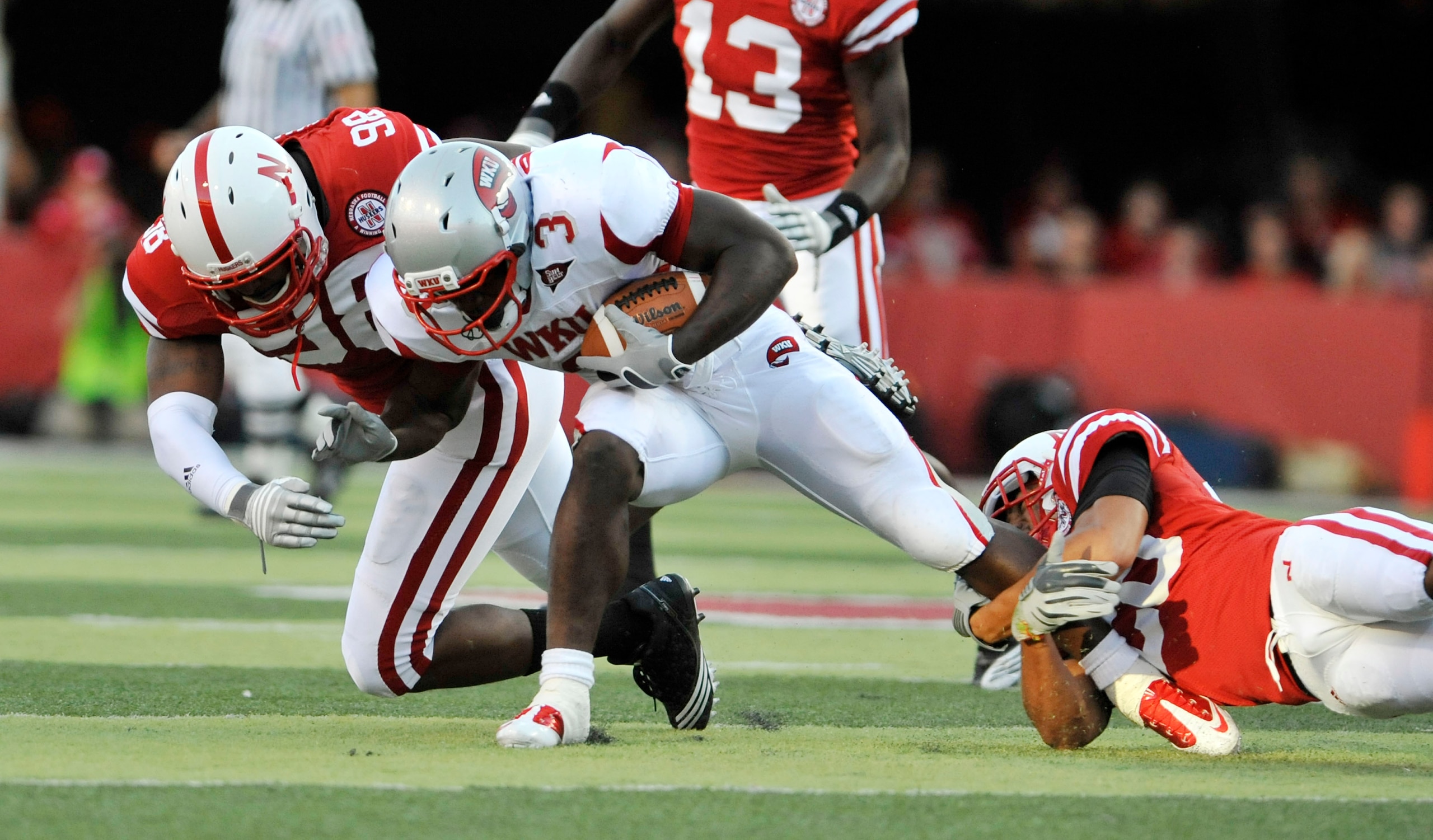 LINCOLN, NE - SEPTEMBER 04:  Bobby Rainey #3 of the Western Kentucky Hilltoppers gets brought down by Josh Williams #98 and Eric Hagg #28 of the Nebraska Cornhuskers during first half action of their game at Memorial Stadium on September 4, 2010 in Lincol