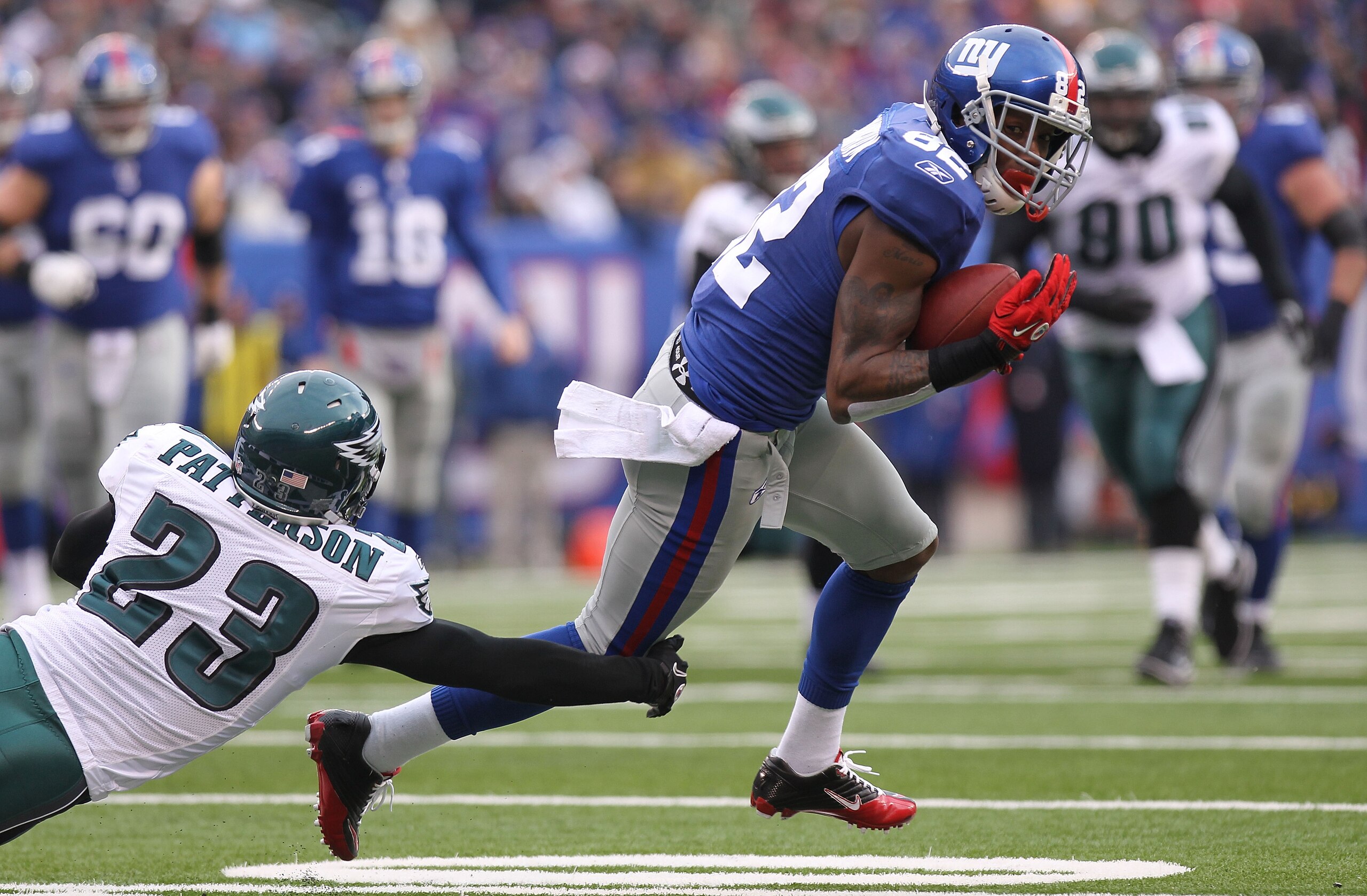 EAST RUTHERFORD, NJ - DECEMBER 19:  Mario Manningham #82 of the New York Giants turns out of the tackle of Dimitri Patterson #23 of the Philadelphia Eagles on his way to a touchdown at New Meadowlands Stadium on December 19, 2010 in East Rutherford, New J