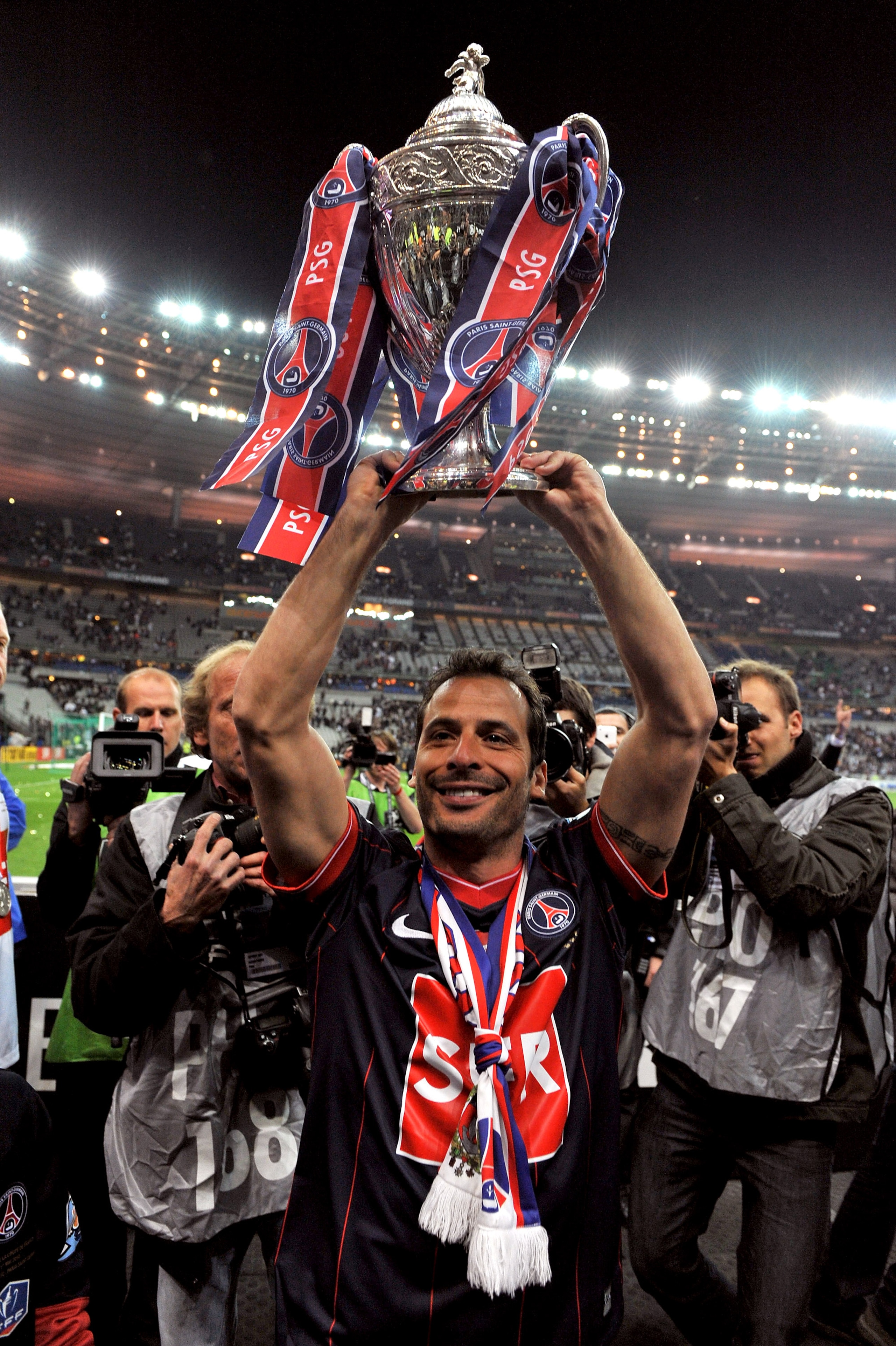 PARIS - MAY 01: Paris Saint-Germain's French Striker Ludovic Giuly holds the trophy to celebrate the winning of the French Cup final between Paris Saint Germain football club and A.S Monaco at Stade de France on May 1, 2010 in Paris, France. Paris Saint G PARIS - MAY 01: Paris Saint-Germain's French Striker Ludovic Giuly holds the trophy to celebrate the winning of the French Cup final between Paris Saint Germain football club and A.S Monaco at Stade de France on May 1, 2010 in Paris, France. Paris Saint G