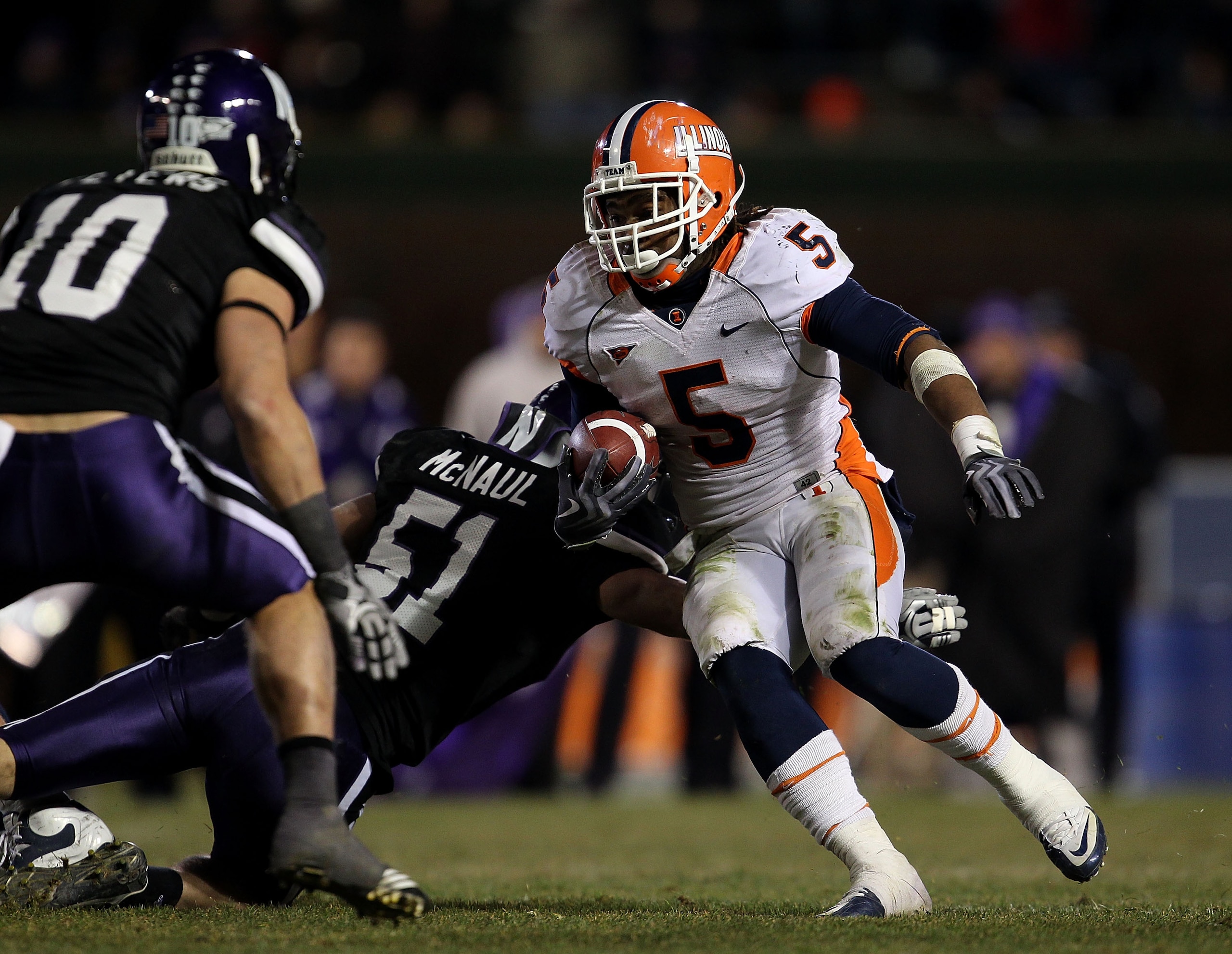 CHICAGO - NOVEMBER 20: Mikel Leshoure #5 of the Illinois Fighting Illini runs past Bryce McNaul #51 of the Northwestern Wildcats and towards Brian Peters #10 on his way to a 339 yard rushing performance during a game played at Wrigley Field on November 20