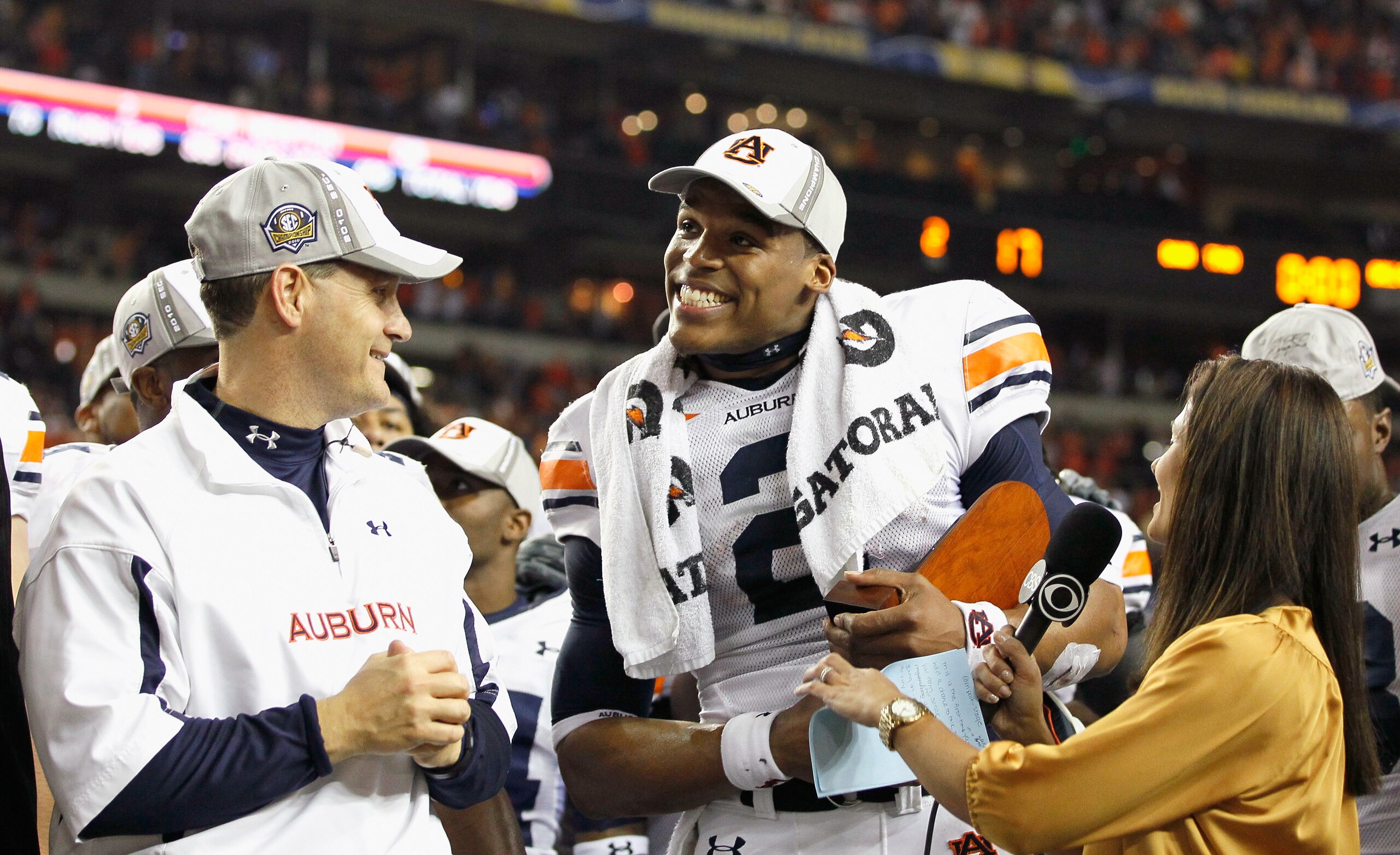 ATLANTA, GA - DECEMBER 04: CBS sideline reporter Tracy Wolfson (R) and head coach Gene Chizik look on as quarterback Cam Newton #2 of the Auburn Tigers accepts the MVP trophy after their 56-17 win over the South Carolina Gamecocks during the 2010 SEC Cha ATLANTA, GA - DECEMBER 04: CBS sideline reporter Tracy Wolfson (R) and head coach Gene Chizik look on as quarterback Cam Newton #2 of the Auburn Tigers accepts the MVP trophy after their 56-17 win over the South Carolina Gamecocks during the 2010 SEC Cha