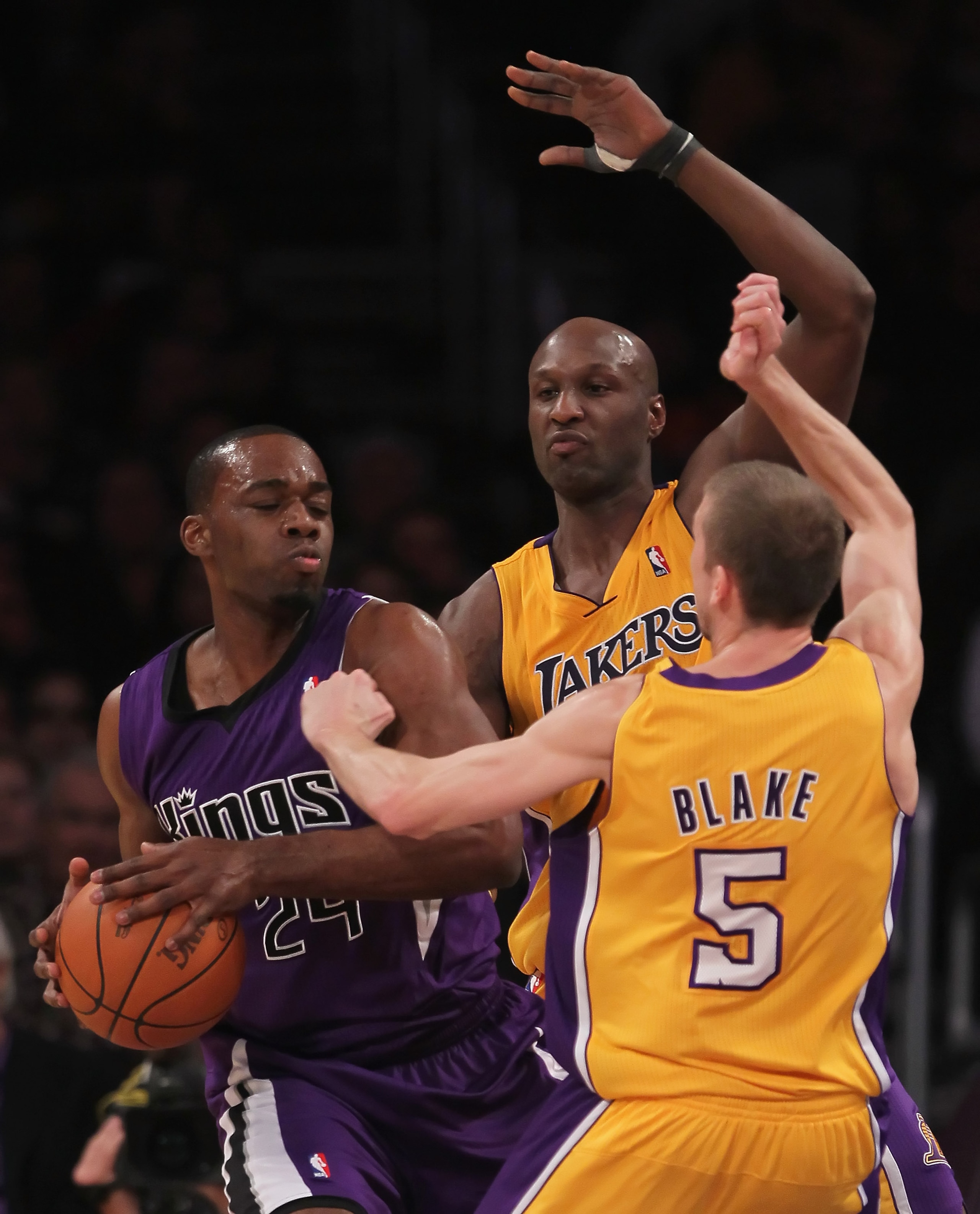LOS ANGELES, CA - DECEMBER 03:  (L-R) Carl Landry #24 of the Sacramento Kings is defended by Lamar Odom #7 and Steve Blake #5 of the Los Angeles Lakers during the first half at Staples Center on December 3, 2010 in Los Angeles, California. The Lakers defe