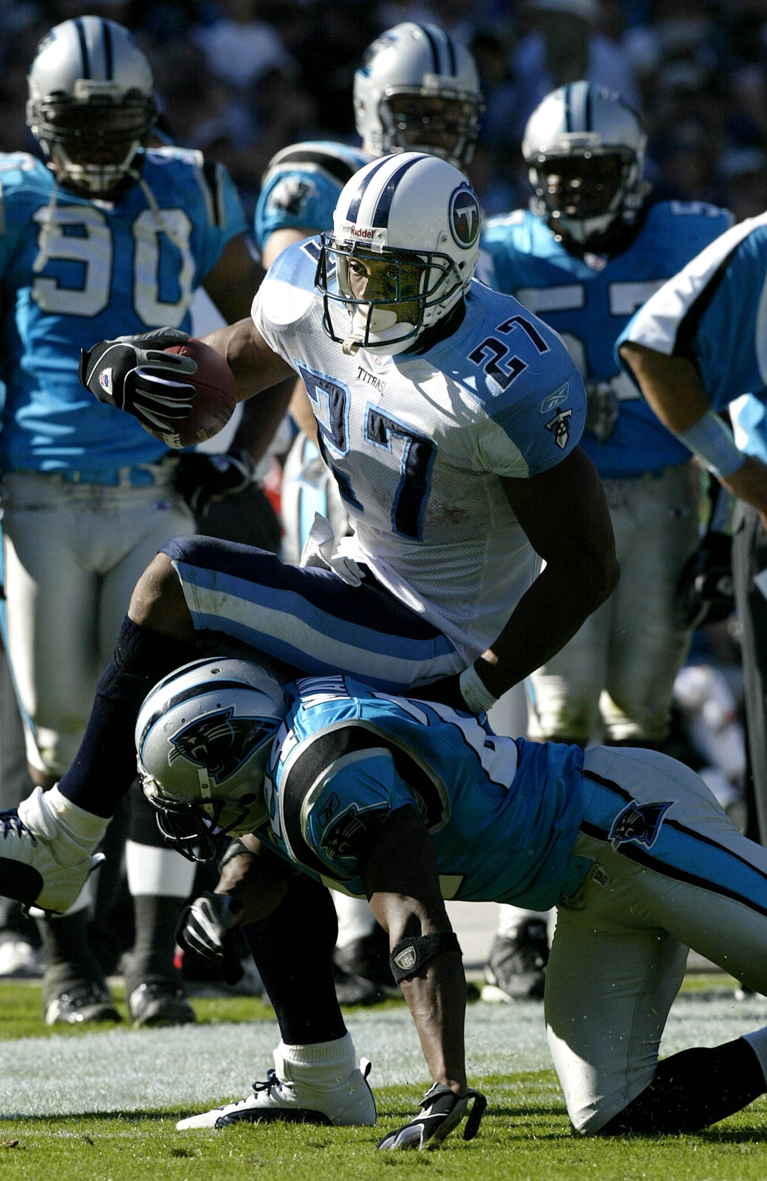 CHARLOTTE, NC - OCTOBER 19:  Eddie George #27 of the Tennessee Titans jumps over Ricky Manning Jr. #24 of the Carolina Panthers on October 19, 2003 at Ericsson Stadium in Charlotte, North Carolina.  (Photo by Craig Jones/Getty Images)