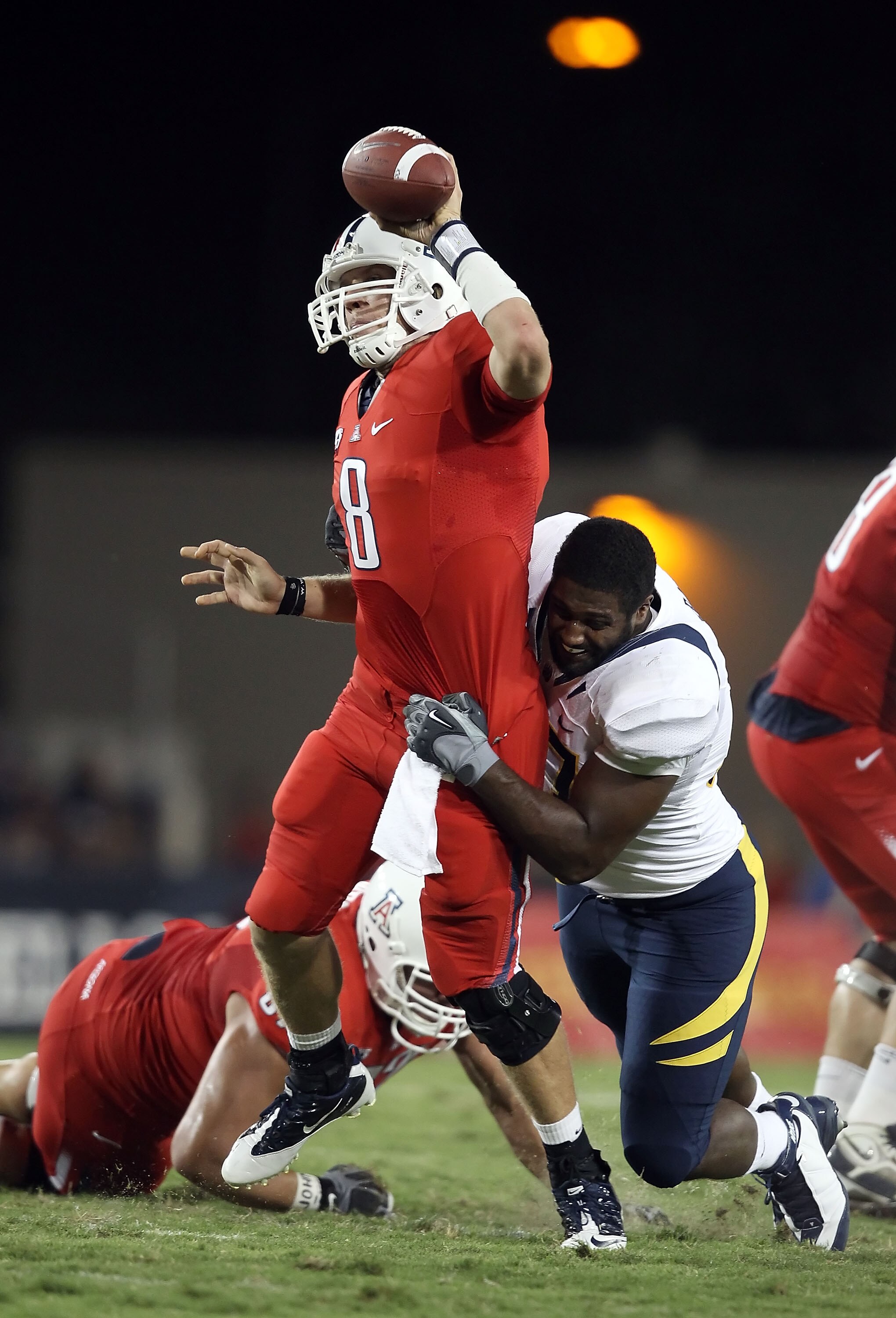 TUCSON, AZ - SEPTEMBER 25:  Quarterback Nick Foles #8 of the Arizona Wildcats is pressured into throwing an incomplete pass by Cameron Jordan #97 of the California Bears during the first quarter of the college football game at Arizona Stadium on September