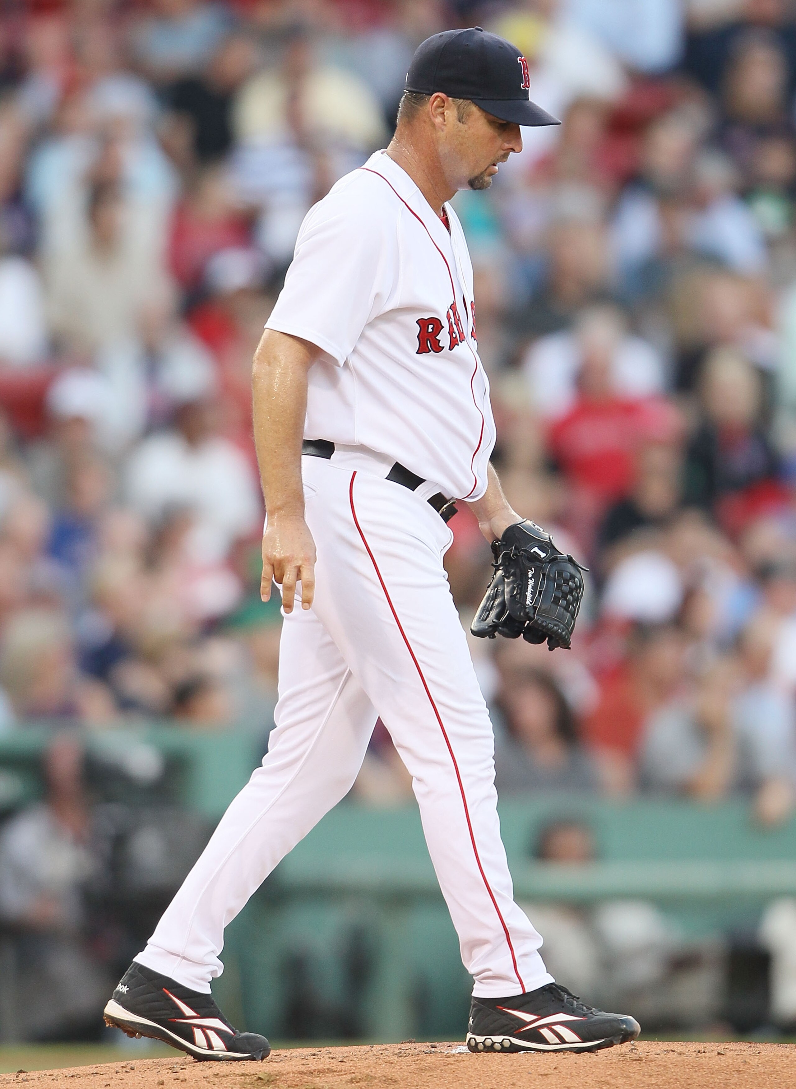 BOSTON - JULY 15:  Tim Wakefield #49 of the Boston Red Sox heads back to the mound after giving up a run in the first inning against the Texas Rangers on July 15, 2010 at Fenway Park in Boston, Massachusetts.  (Photo by Elsa/Getty Images)