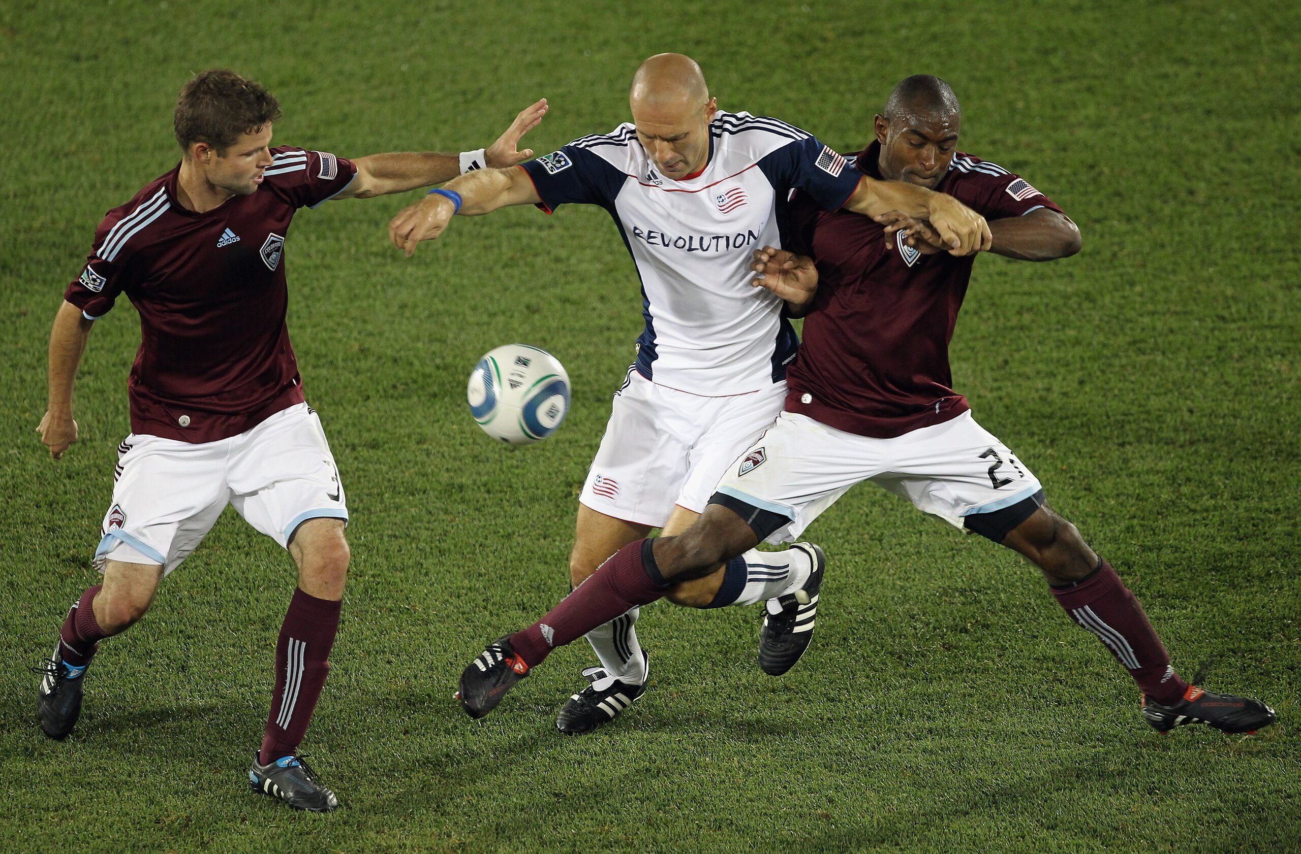 COMMERCE CITY, CO - SEPTEMBER 18:  Drew Moor #3 and Marvell Wynne #22 of the Colorado Rapids try to protect the ball from Ilija Stolica #9 of the New England Revolution at Dick's Sporting Goods Park on September 18, 2010 in Commerce City, Colorado. The Ra