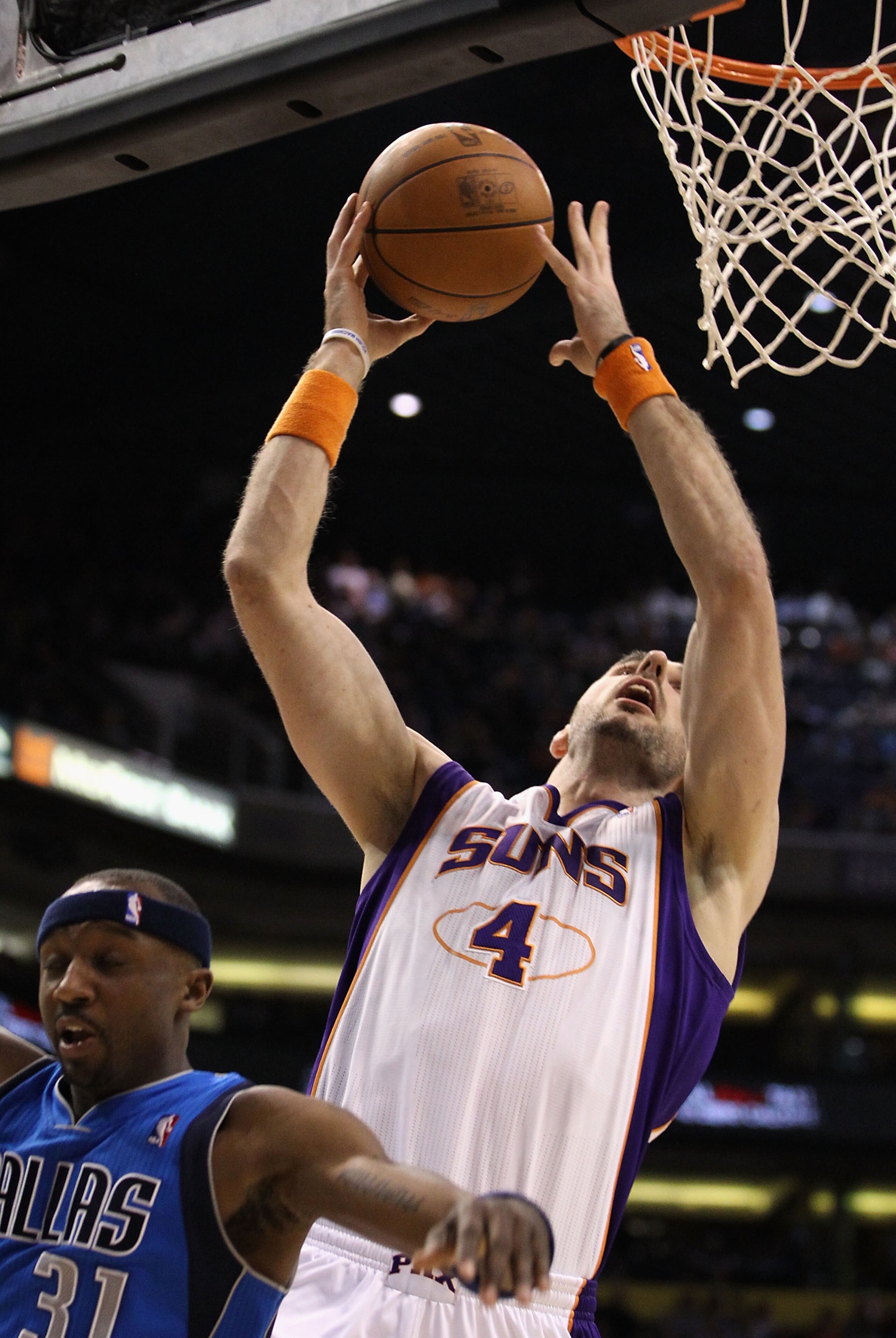 PHOENIX, AZ - FEBRUARY 17:  Marcin Gortat #4 of the Phoenix Suns puts up a shot over Jason Terry #31 of the Dallas Mavericks during the NBA game at US Airways Center on February 17, 2011 in Phoenix, Arizona.  NOTE TO USER: User expressly acknowledges and