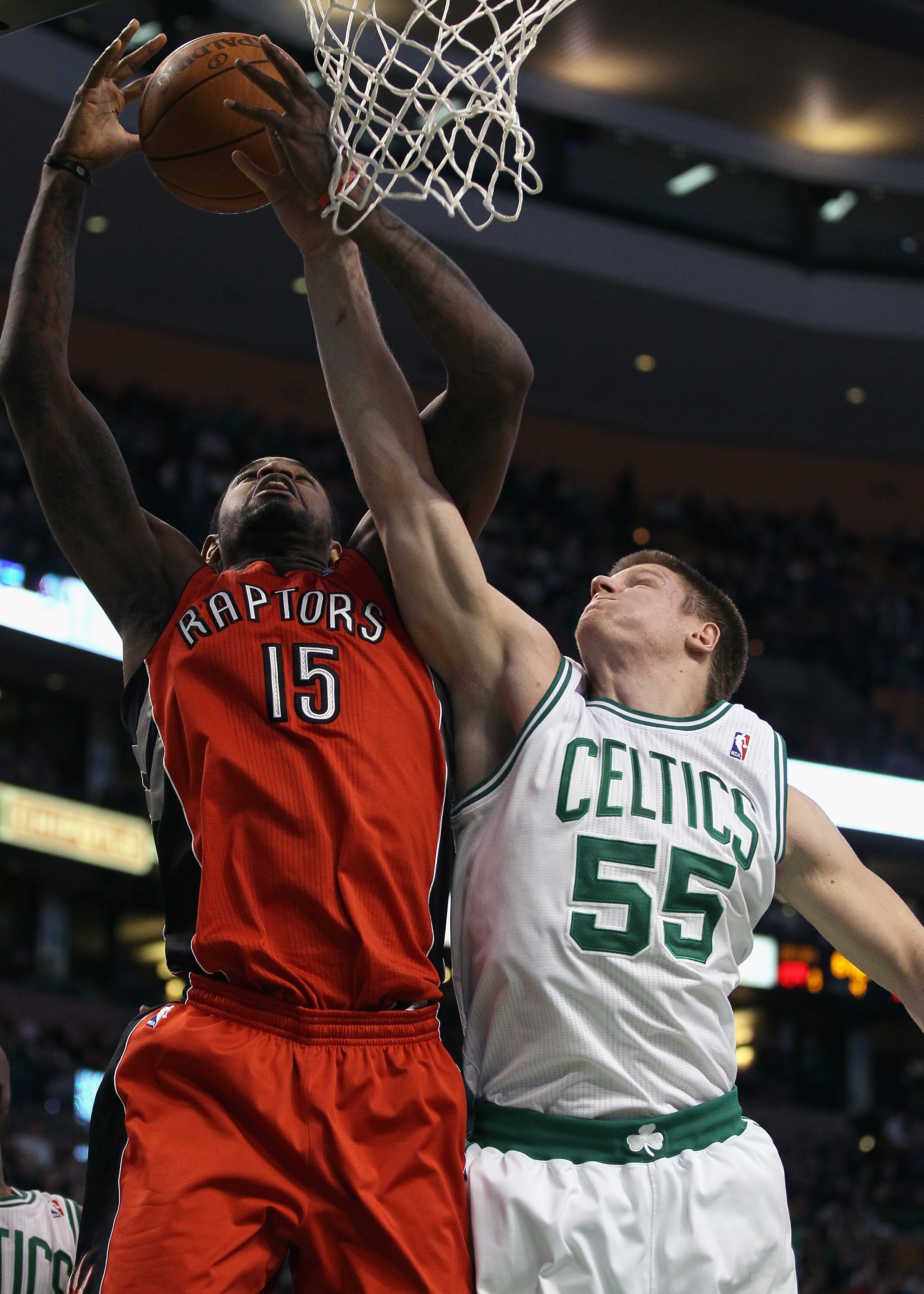 BOSTON, MA - JANUARY 07:  Luke Harangody #55 of the Boston Celtics and Amir Johnson #15 of the Toronto Raptors fight for the rebound on January 7, 2011 at the TD Garden in Boston, Massachusetts. The Celtics defeated the Raptors 122-102. NOTE TO USER: User