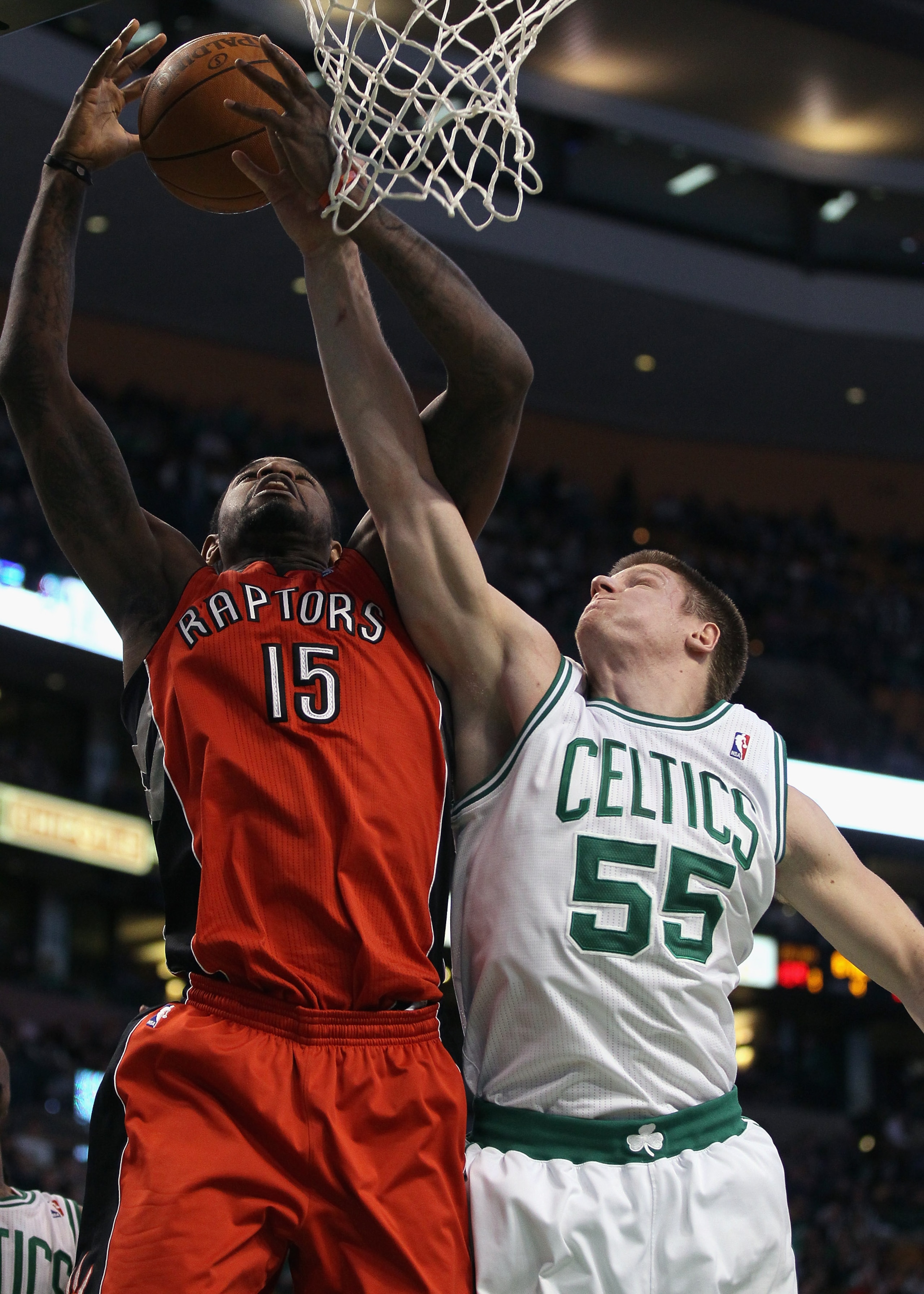 BOSTON, MA - JANUARY 07:  Luke Harangody #55 of the Boston Celtics and Amir Johnson #15 of the Toronto Raptors fight for the rebound on January 7, 2011 at the TD Garden in Boston, Massachusetts. The Celtics defeated the Raptors 122-102. NOTE TO USER: User