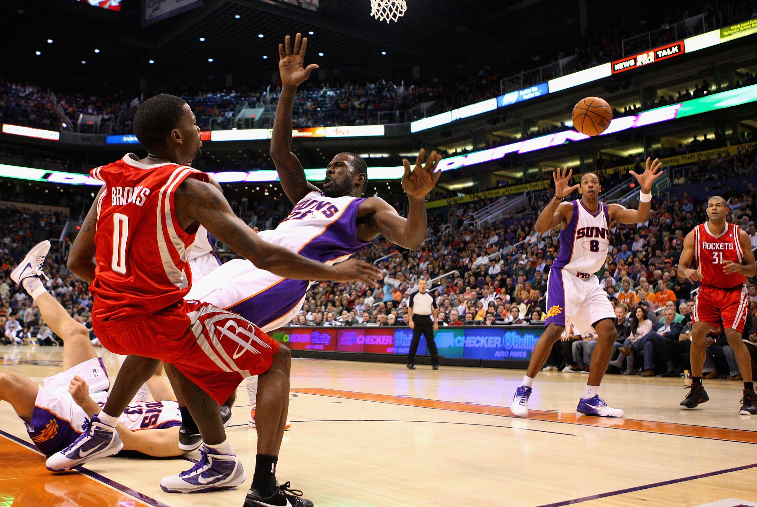 PHOENIX - JANUARY 06:  Aaron Brooks #0 of the Houston Rockets passes the ball to teammate Shane Battier #31 under pressure from Jason Richardson #23 and Channing Frye #8 of the Phoenix Suns during the NBA game at US Airways Center on January 6, 2010 in Ph
