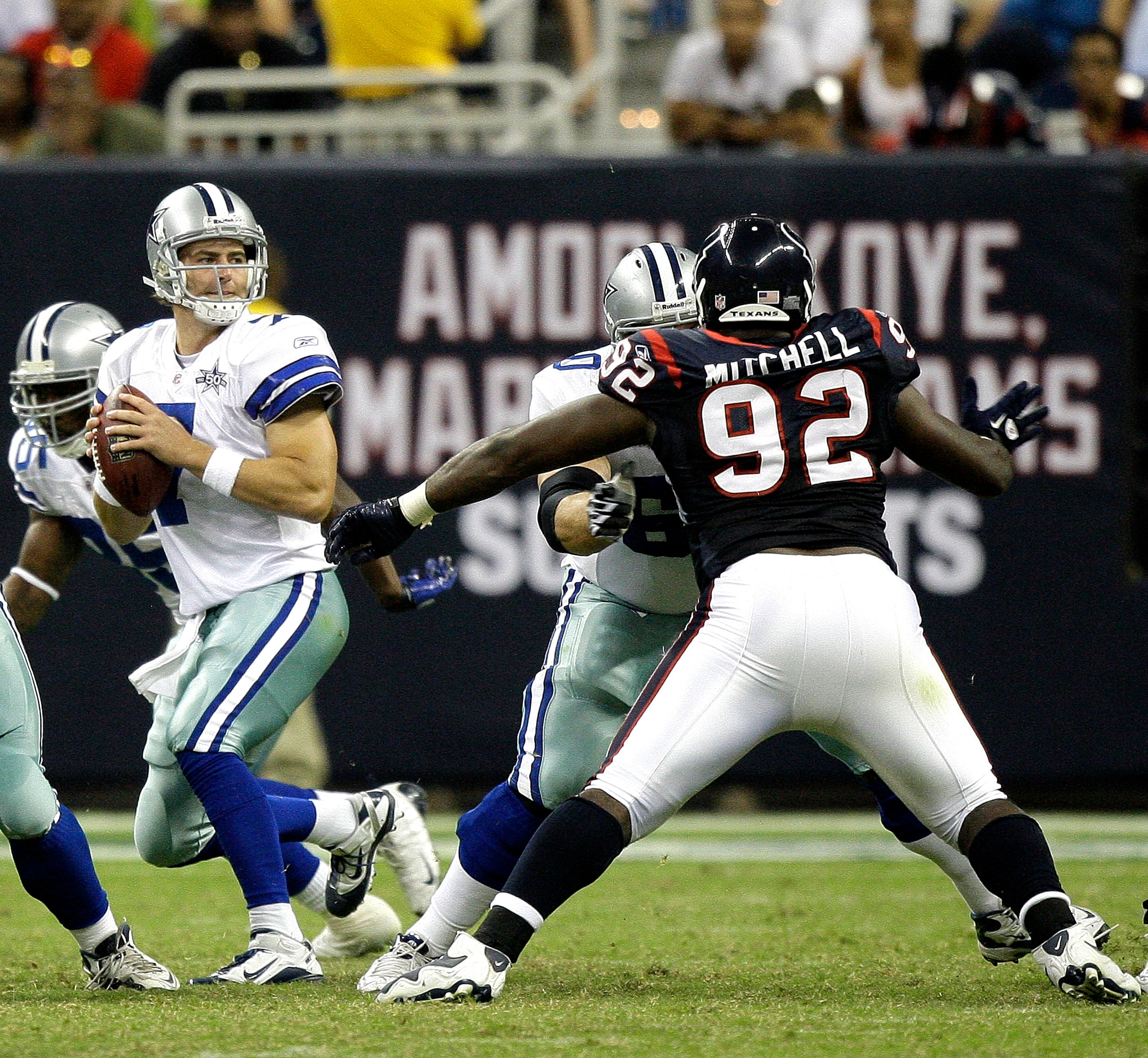 HOUSTON - AUGUST 28: Quarterback Stephen McGee #7 of the Dallas Cowboys looks for a receiver as he receives pressure from defensive tackle Earl Mitchell #92 of the Houston Texans at Reliant Stadium on August 28, 2010 in Houston, Texas. (Photo by Bob Levey