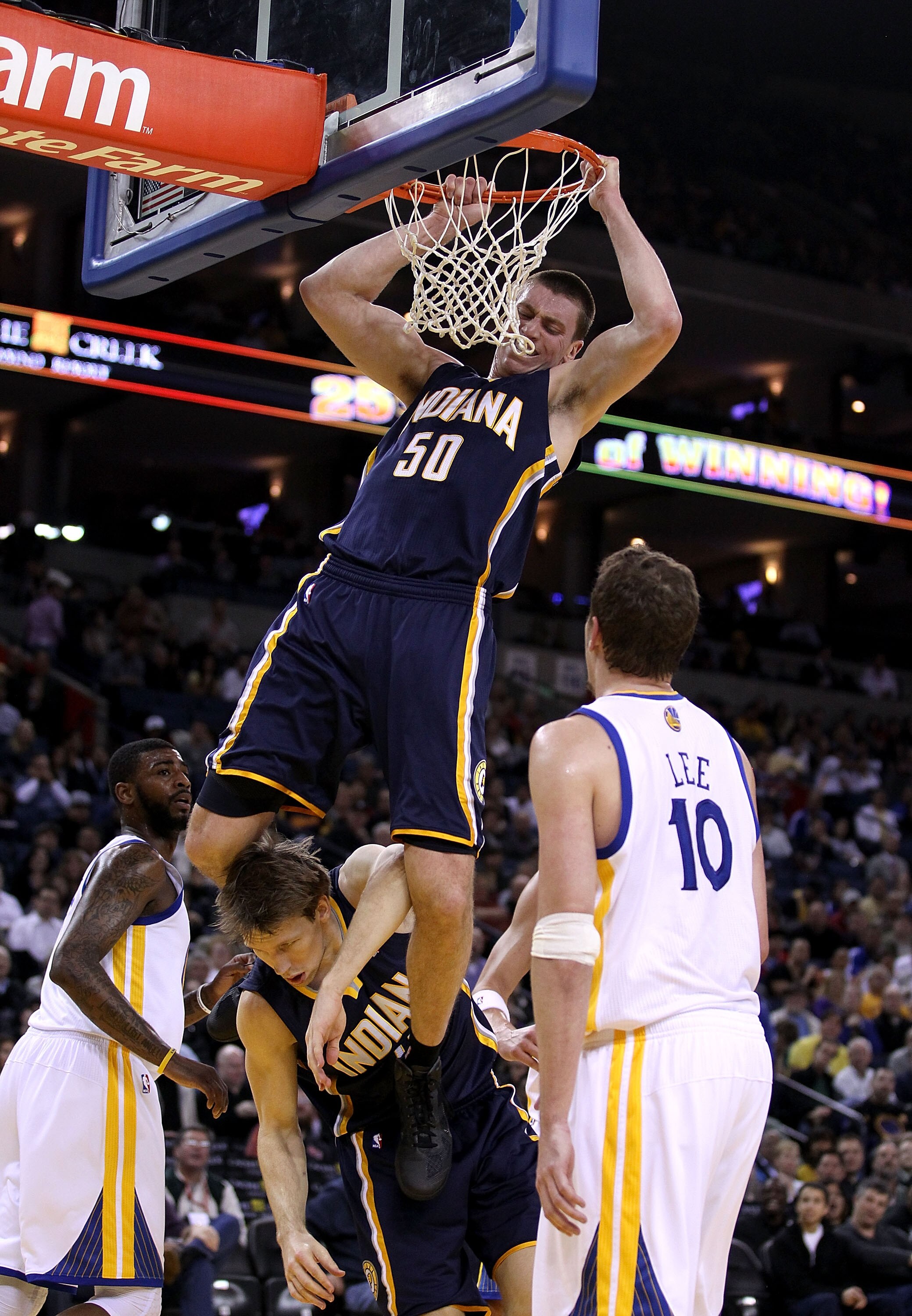 OAKLAND, CA - JANUARY 19:  Tyler Hansbrough #50 of the Indiana Pacers hangs on the rim after he dunked the ball so he doesn't land on Mike Dunleavy #17 during their game against the Golden State Warriors at Oracle Arena on January 19, 2011 in Oakland, Cal