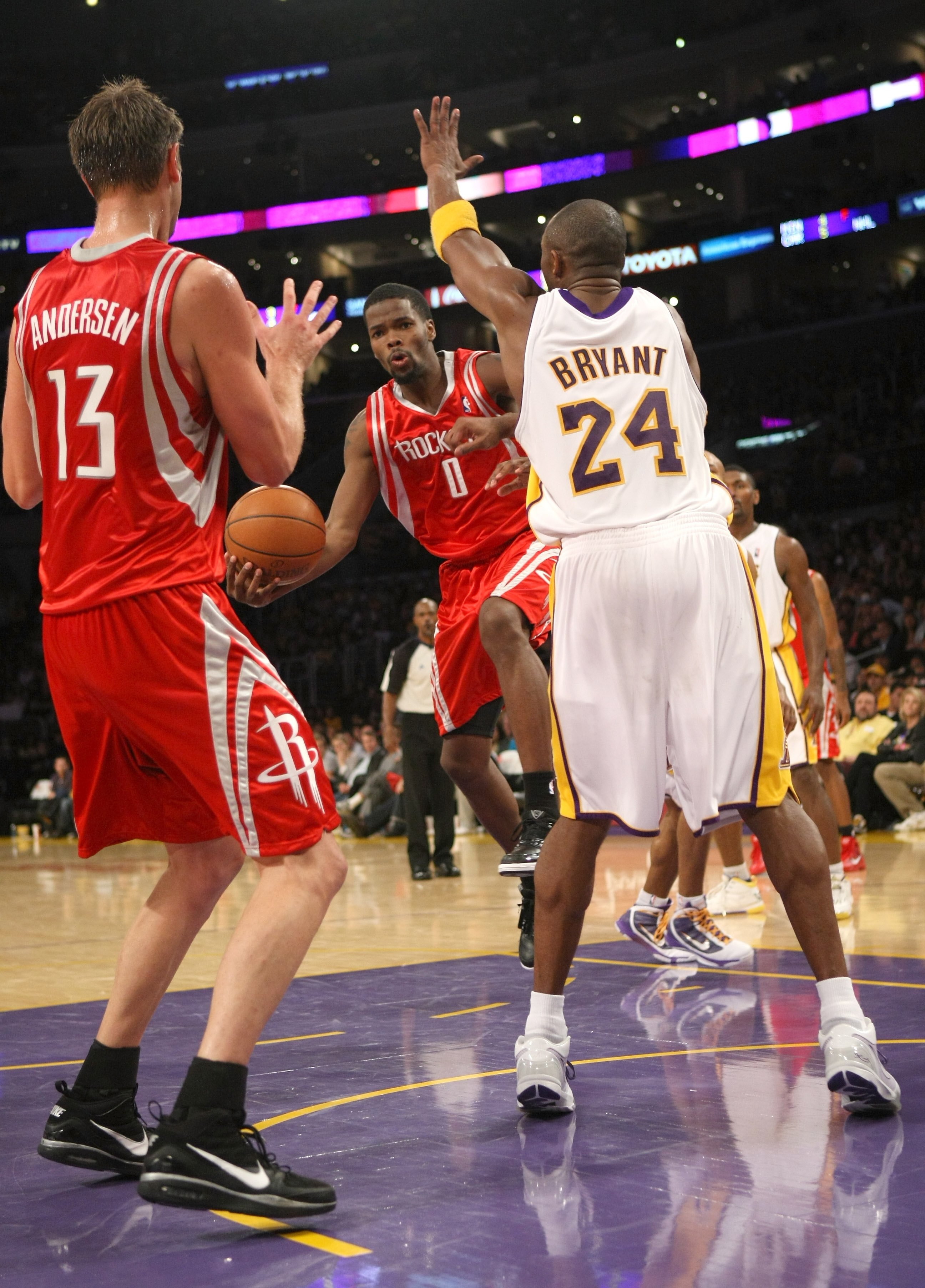 LOS ANGELES, CA - NOVEMBER 15:  Aaron Brooks #0 of the Houston Rockets passes the ball to David Andersen #13 in front of Kobe Bryant #24 of the Los Angeles Lakers on November 15, 2009 at Staples Center in Los Angeles, California.  The Rockets won 101-91.