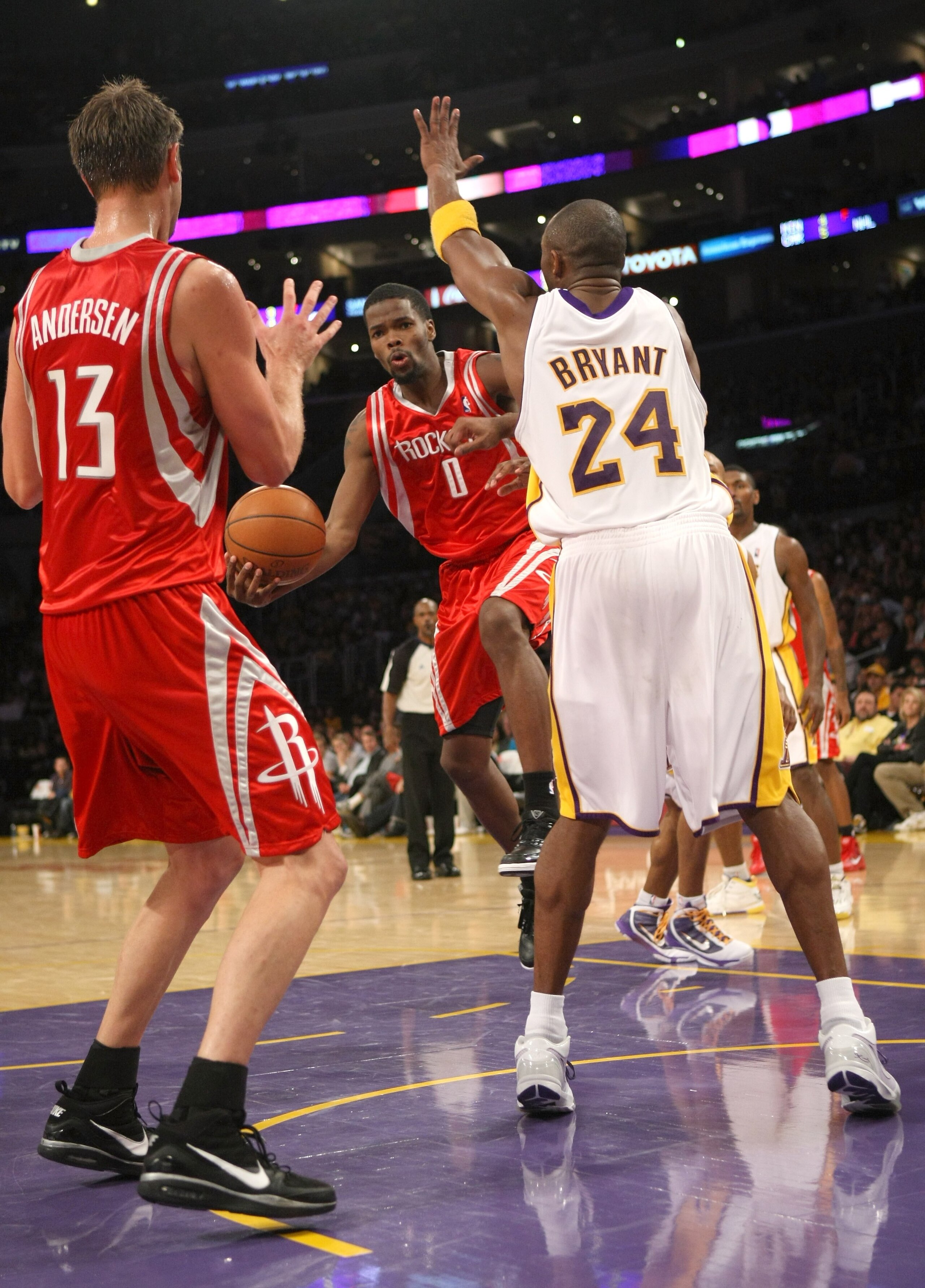 LOS ANGELES, CA - NOVEMBER 15:  Aaron Brooks #0 of the Houston Rockets passes the ball to David Andersen #13 in front of Kobe Bryant #24 of the Los Angeles Lakers on November 15, 2009 at Staples Center in Los Angeles, California.  The Rockets won 101-91.