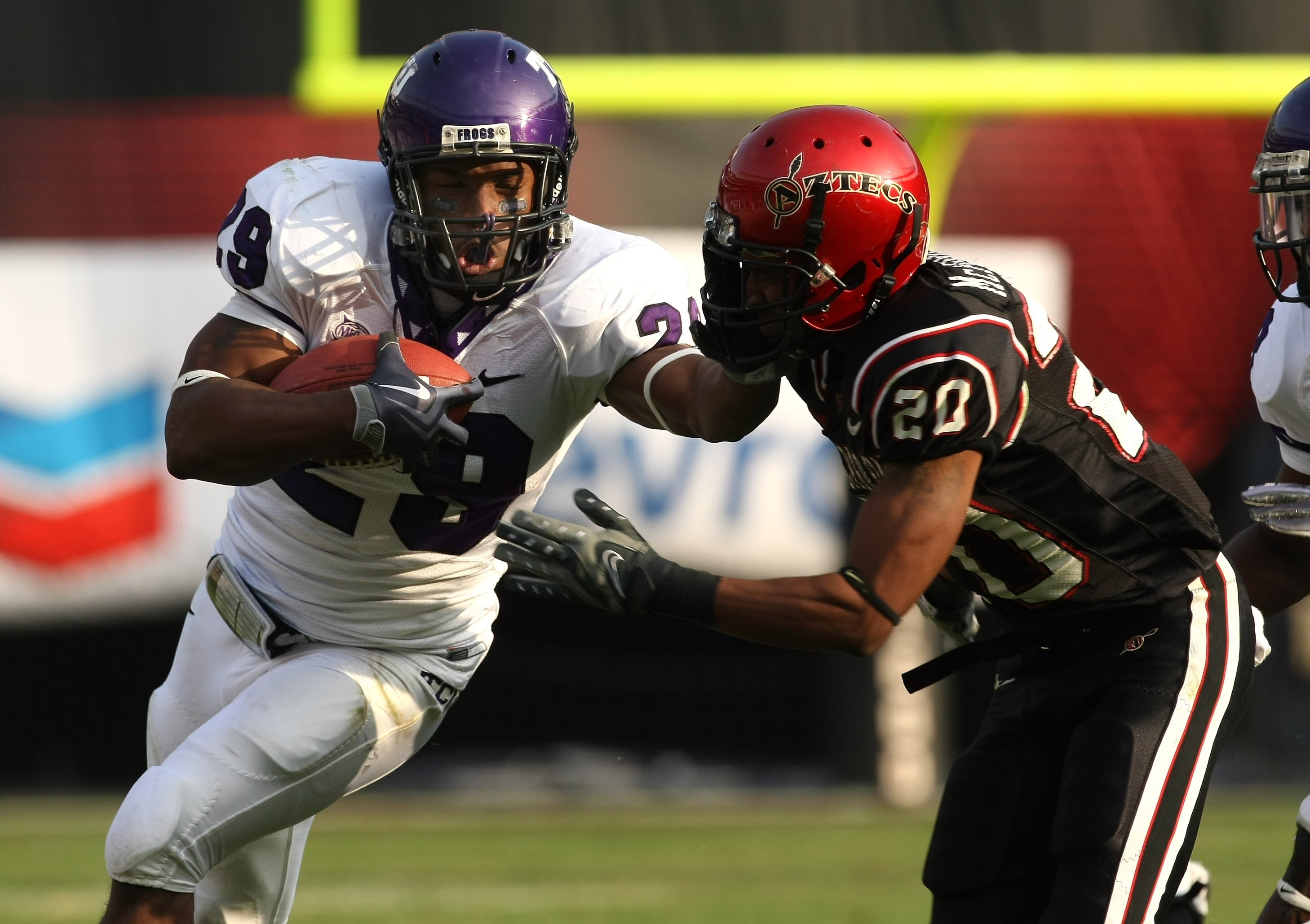 SAN DIEGO - NOVEMBER 07:  Running back Matthew Tucker #29 of the Texas Christian University Horned Frogs carries the ball as he stiffarms corner back Leon McFadden #20 of the San Diego State Aztecs on November 7, 2009 at Qualcomm Stadium in San Diego, Cal