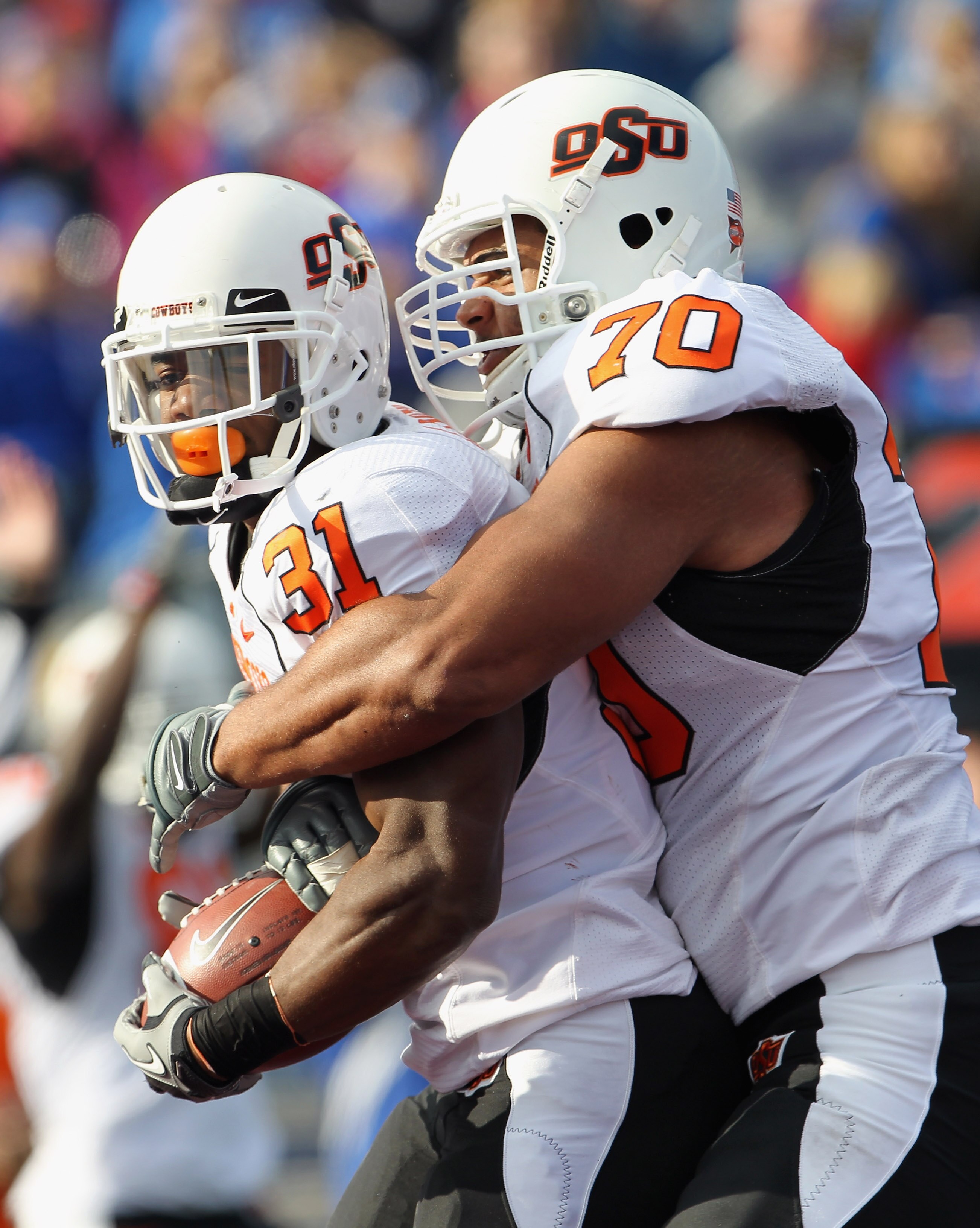 LAWRENCE, KS - NOVEMBER 20: Jeremy Smith #31 of the Oklahoma State Cowboys is congratulated by Jonathan Rush #70 after a touchdown during the game against the Kansas Jayhawks on November 20, 2010 at Memorial Stadium in Lawrence, Kansas.  (Photo by Jamie S