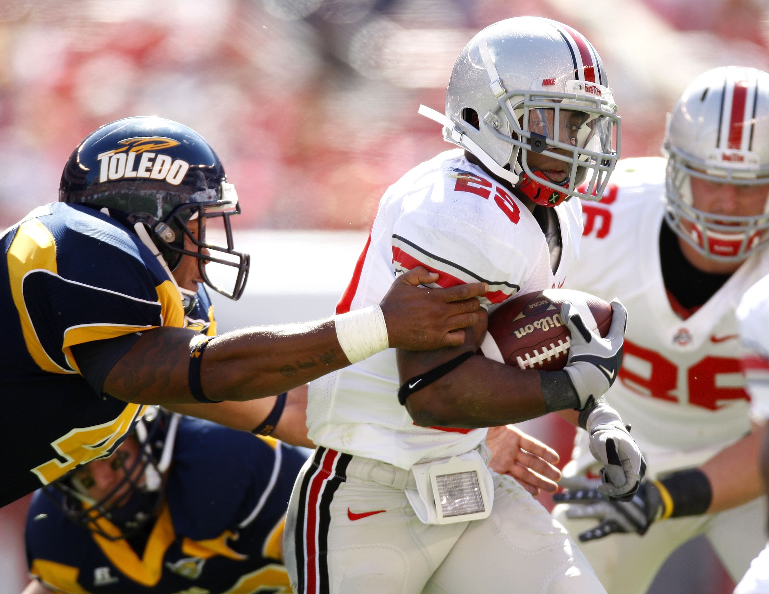 CLEVELAND - SEPTEMBER 19:  Jordan Hall #29 of the Ohio State Buckeyes tries to get around the tackle of Archie Donald #42 of the Toledeo Rockets on September 19, 2009 at Cleveland Browns Stadium in Cleveland, Ohio. Ohio State won the game 38-0.  (Photo by