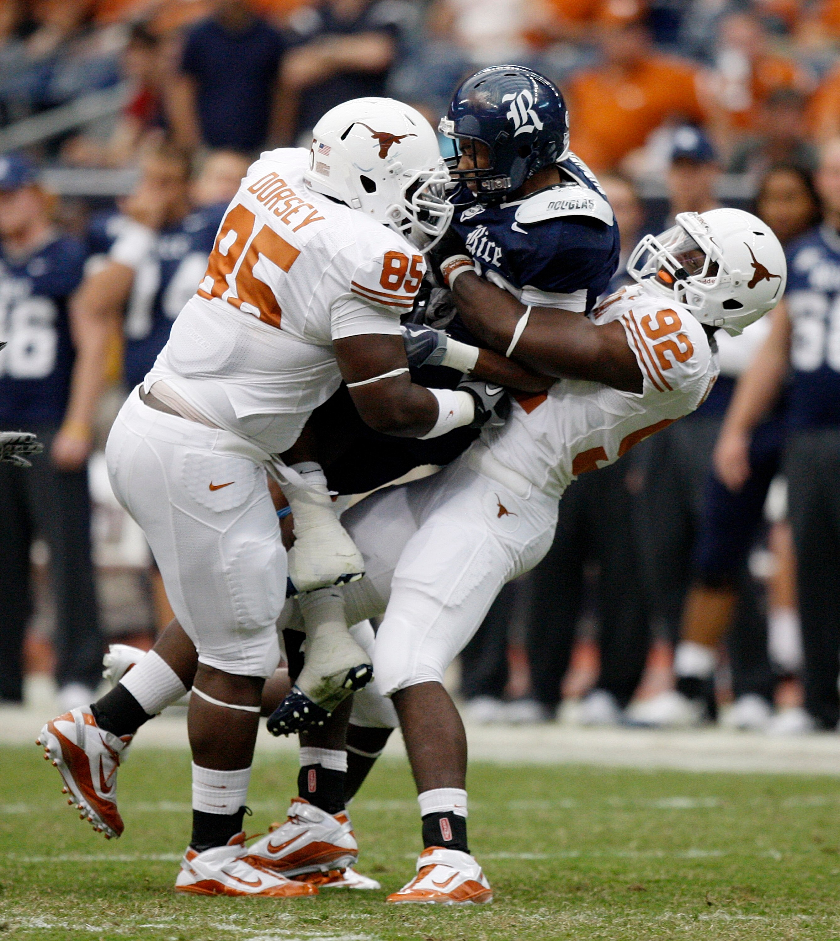 HOUSTON - SEPTEMBER 04:  Running back Shane Turner #23 of the Rice Owls is sanwiched between defensive lineman Ashton Dorsey #85 and defensive lineman Reggie Wilson #92 of the Texas Longhorns at Reliant Stadium on September 4, 2010 in Houston, Texas. Texa