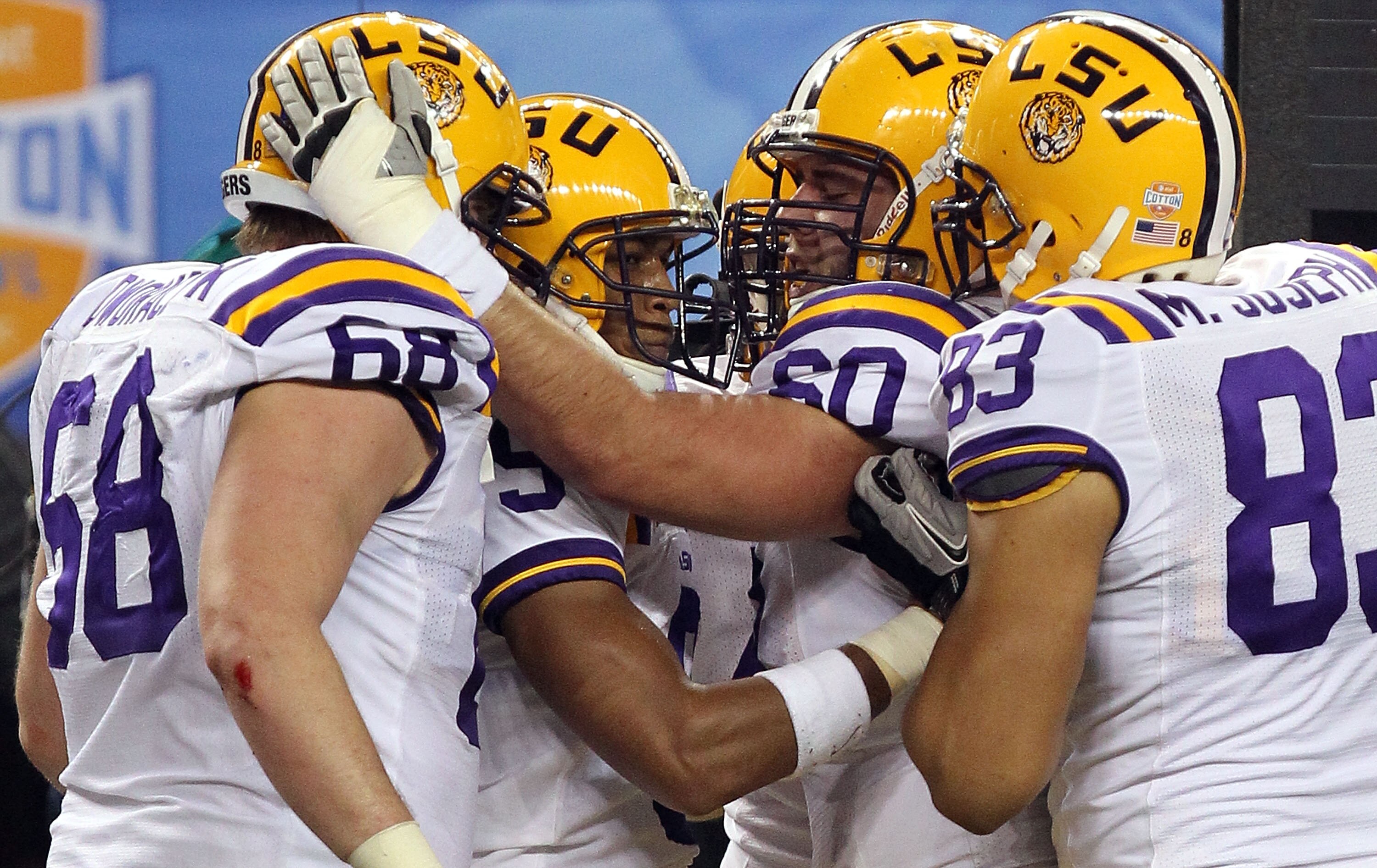 ARLINGTON, TX - JANUARY 07:  (L-R) Josh Dworaczyk #68, Jordan Jefferson #9, Will Blackwell #60 and Mitch Joseph #83 of the LSU Tigers celebrate a touchdown against the Texas A&M Aggies during the AT&T Cotton Bowl at Cowboys Stadium on January 7, 2011 in A