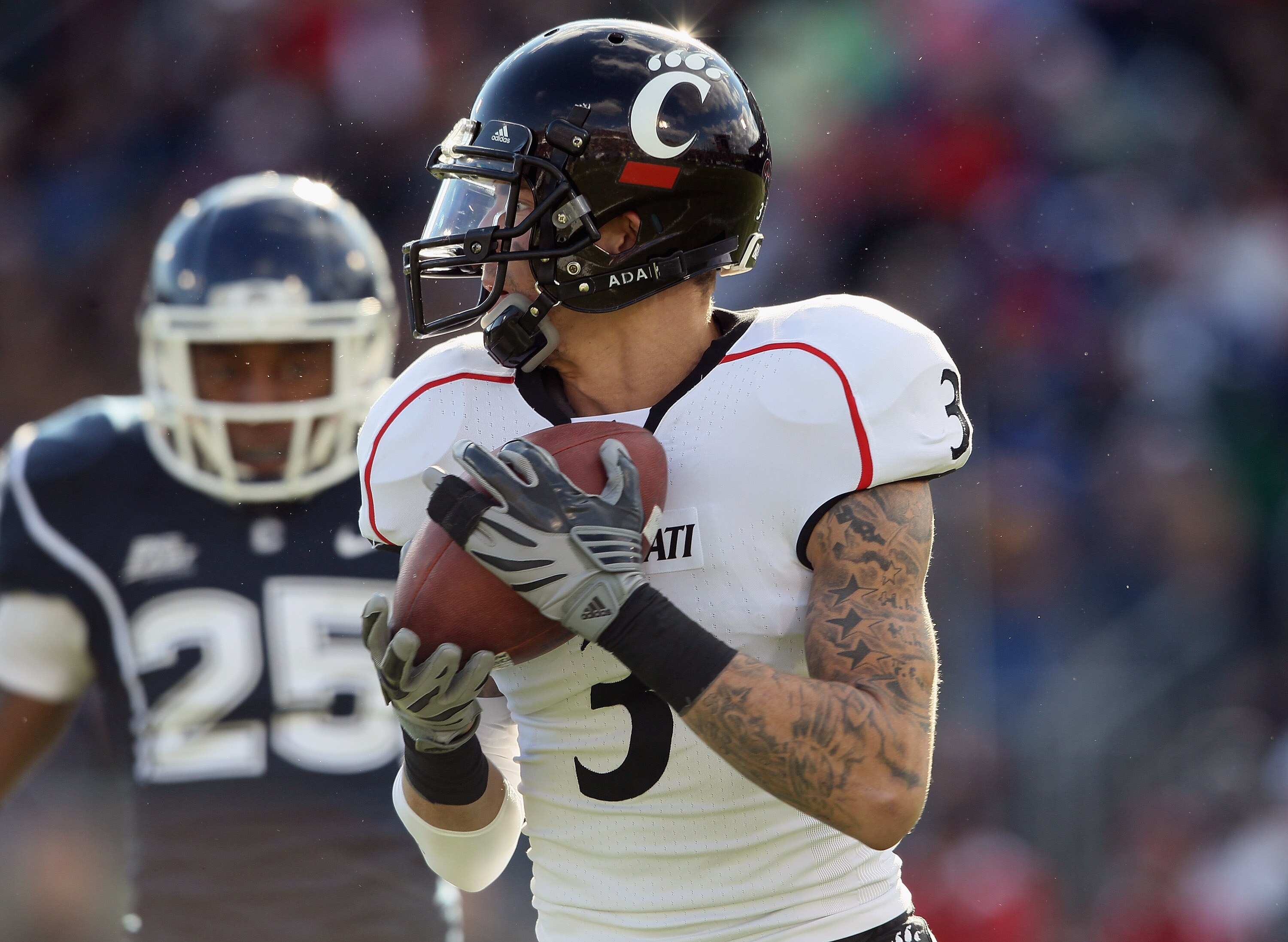 EAST HARTFORD, CT - NOVEMBER 27:  DJ Woods #3 of the Cincinnati Bearcats carries the gall as Harris Agbor #25 of the Connecticut Huskies defends on November 27, 2010 at Rentschler Field in East Hartford, Connecticut.  (Photo by Elsa/Getty Images)