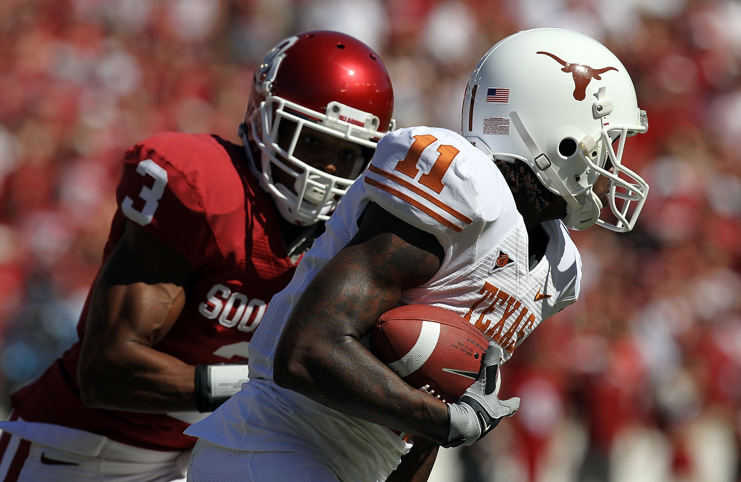 DALLAS - OCTOBER 02:  Wide receiver James Kirkendoll #11 of the Texas Longhorns runs past Jonathan Nelson #3 of the Oklahoma Sooners in the first quarter at the Cotton Bowl on October 2, 2010 in Dallas, Texas.  (Photo by Ronald Martinez/Getty Images)